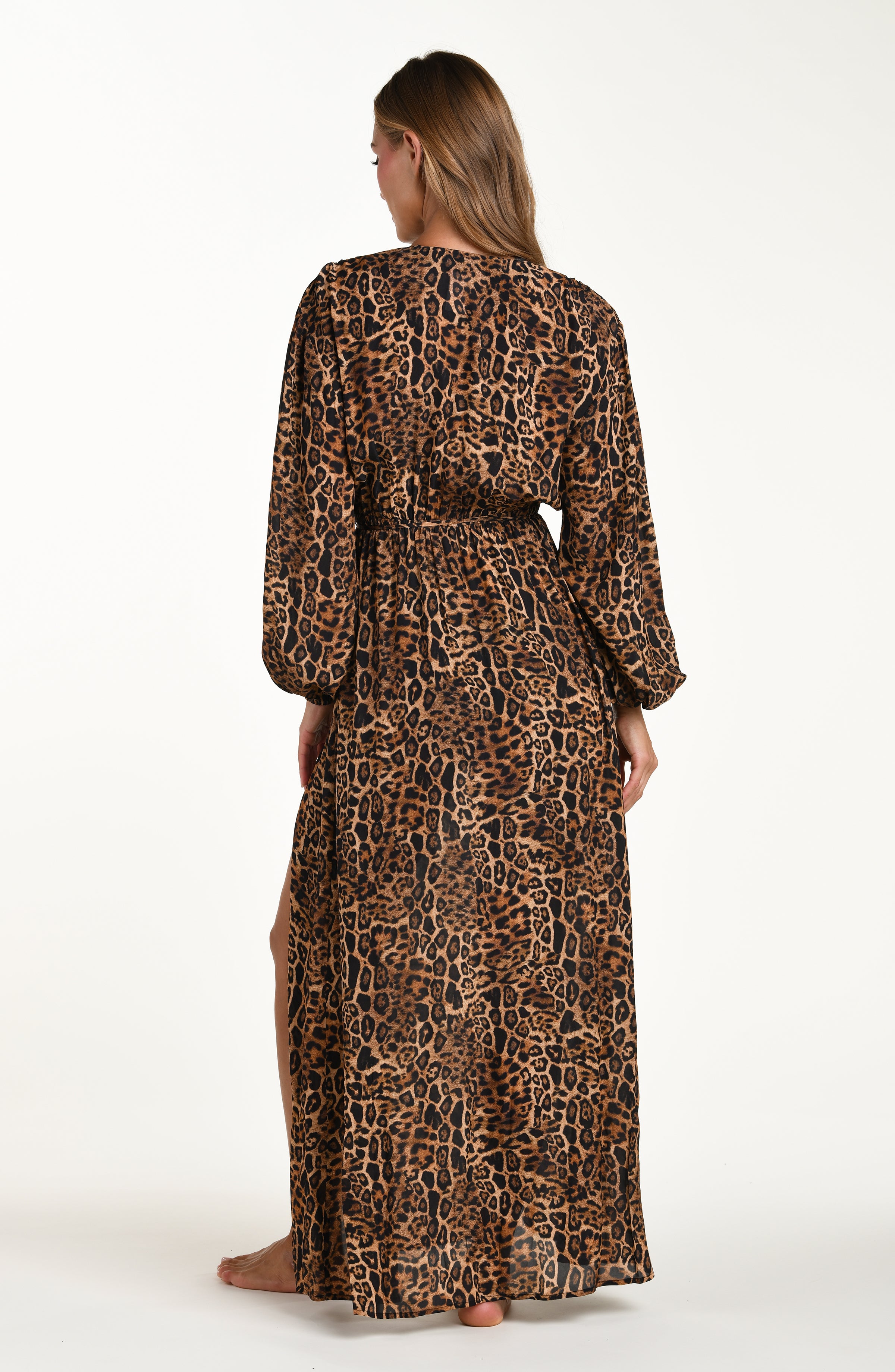 Woman wearing a leopard dress against a white background.