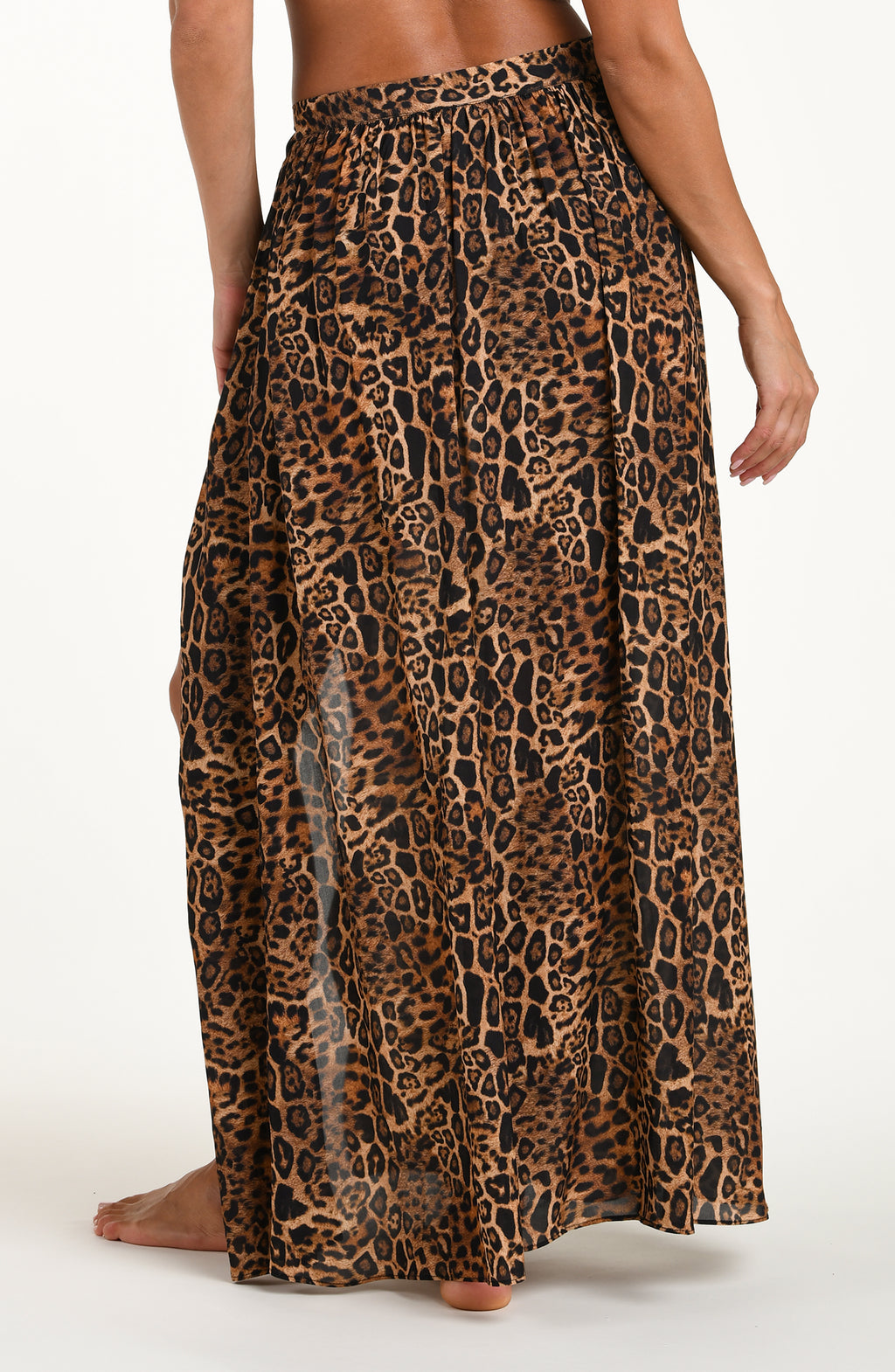 Woman wearing a leopard cover up skirt featuring a maxi length and side tie closure. 