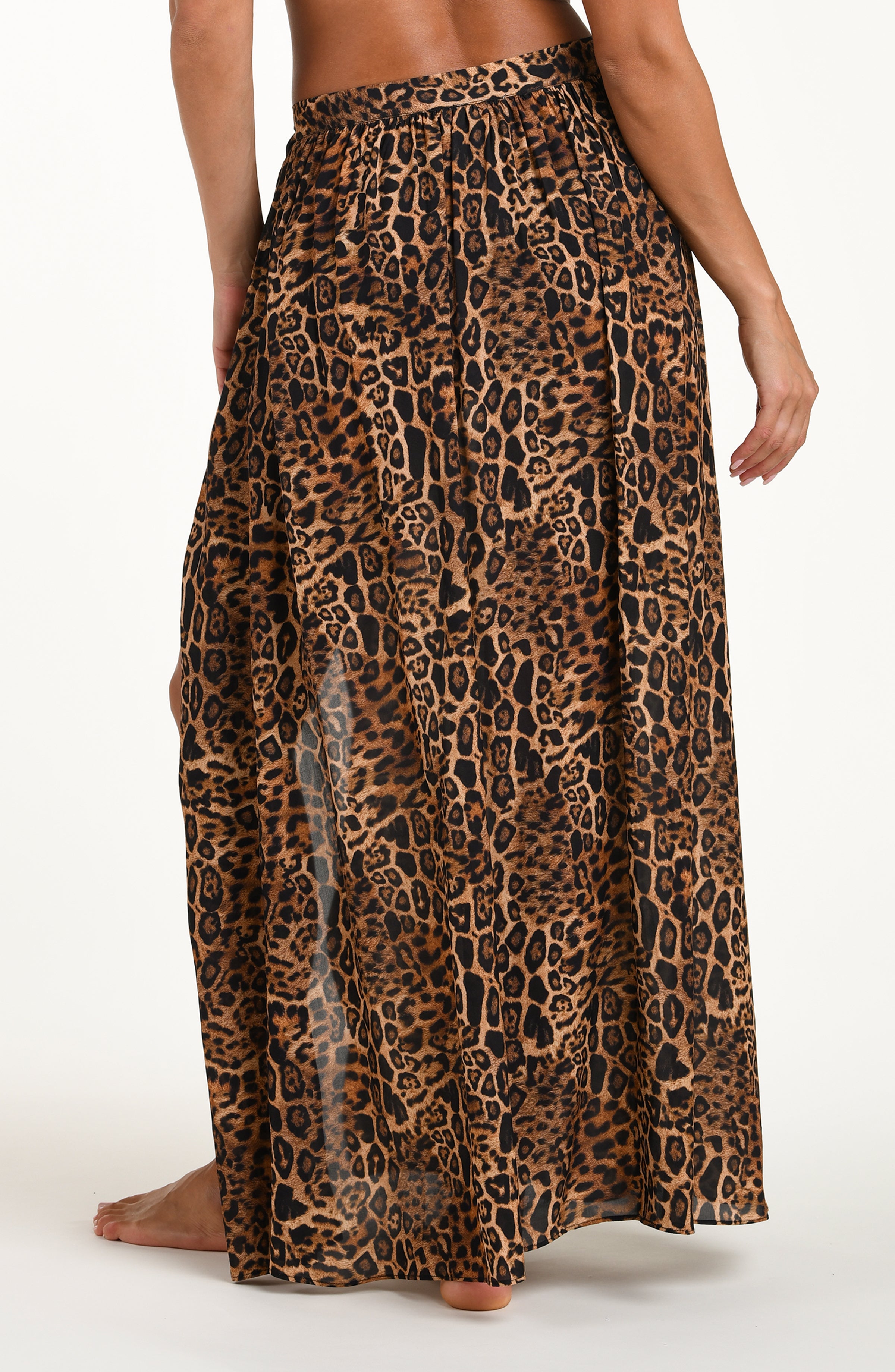 Woman wearing a leopard cover up skirt featuring a maxi length and side tie closure. 
