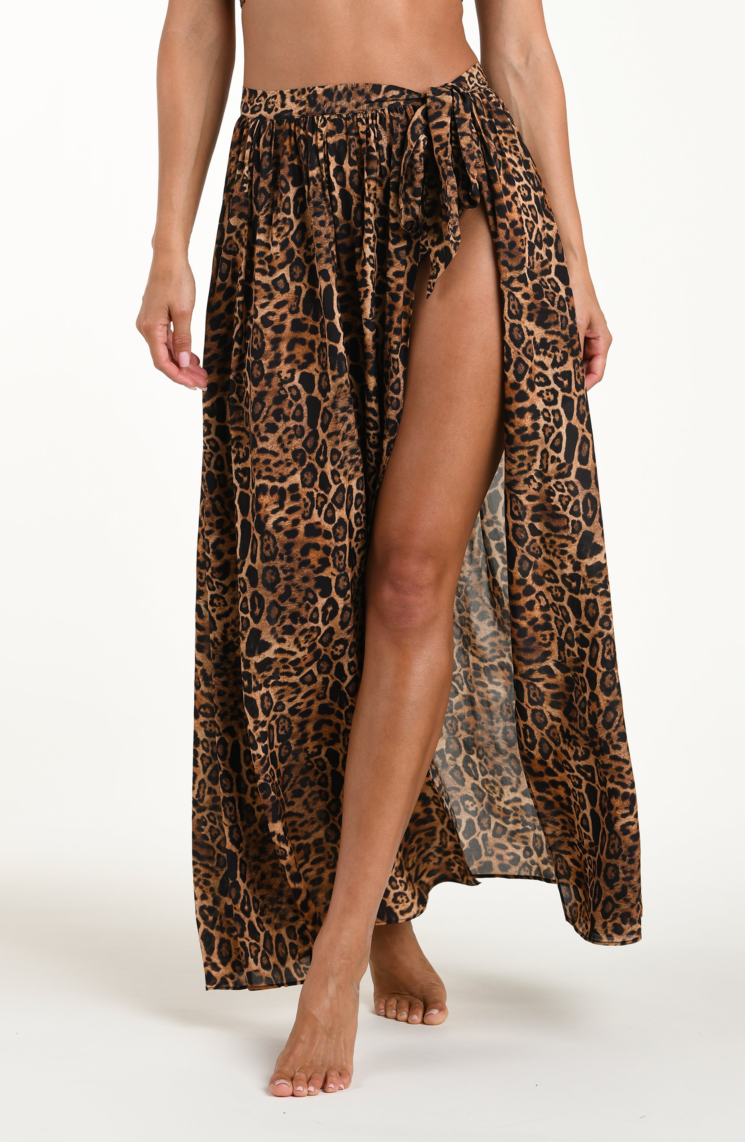 Woman wearing a leopard cover up skirt featuring a maxi length and side tie closure. 