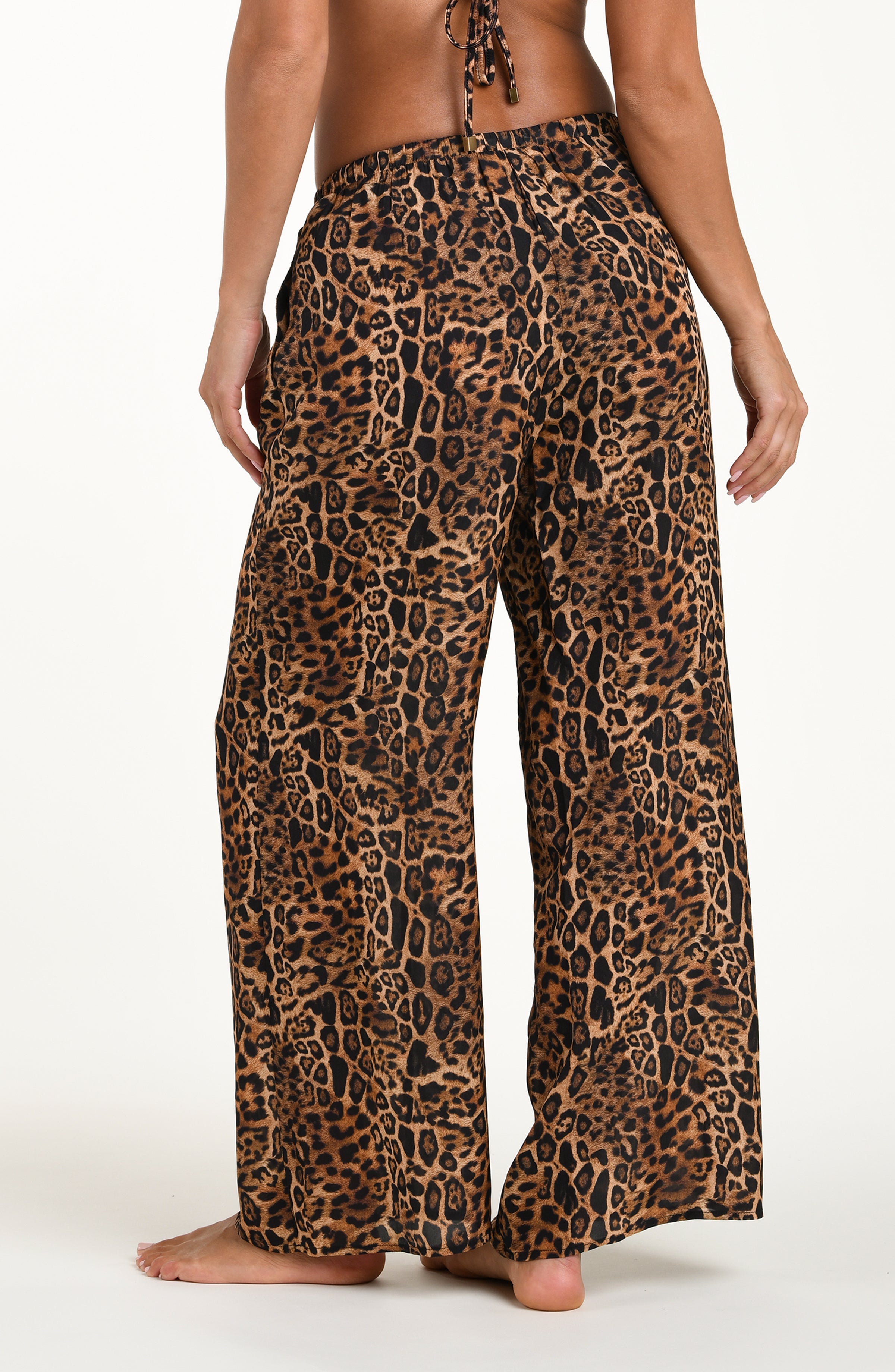 Leopard print pants worn by a person on a white background