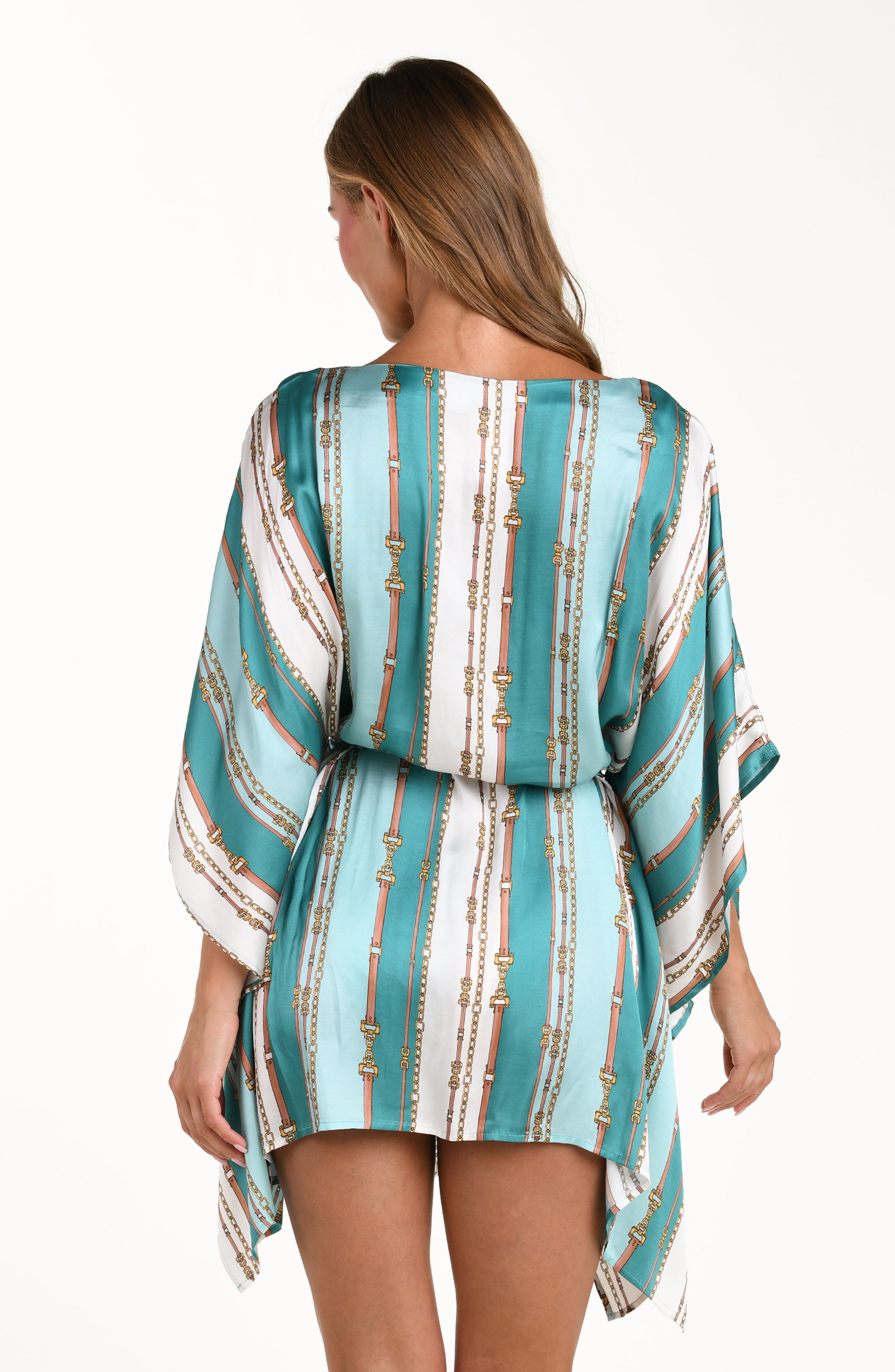 Back image of model wearing a belt-and-chain printed cover up tunic featuring a high neckline, wide sleeves, and removable belt. 