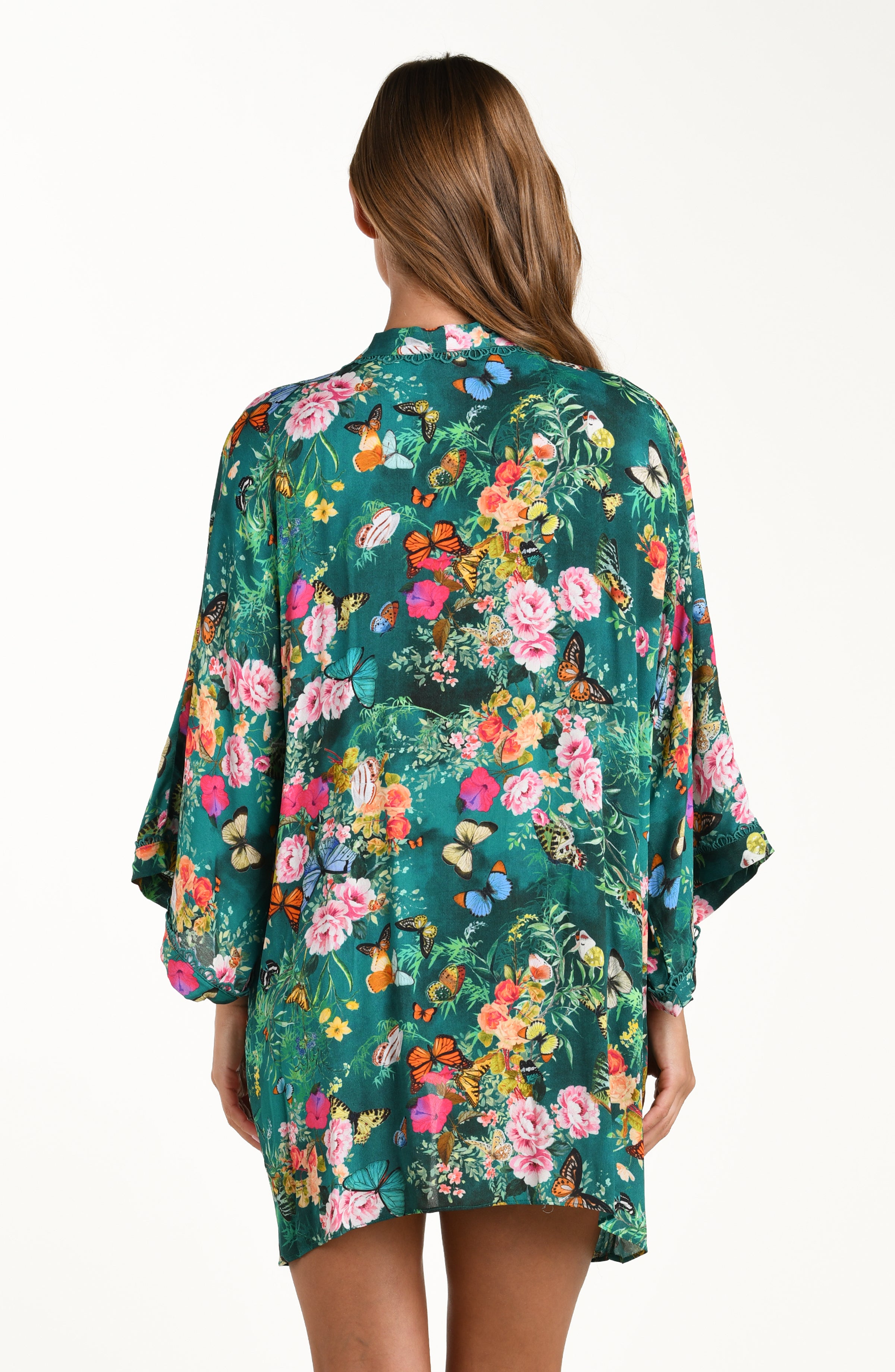 Back image of model wearing a multicolored floral printed kimono cover up featuring a clean back, long wide sleeves, and a removable faux pearl belt. 
