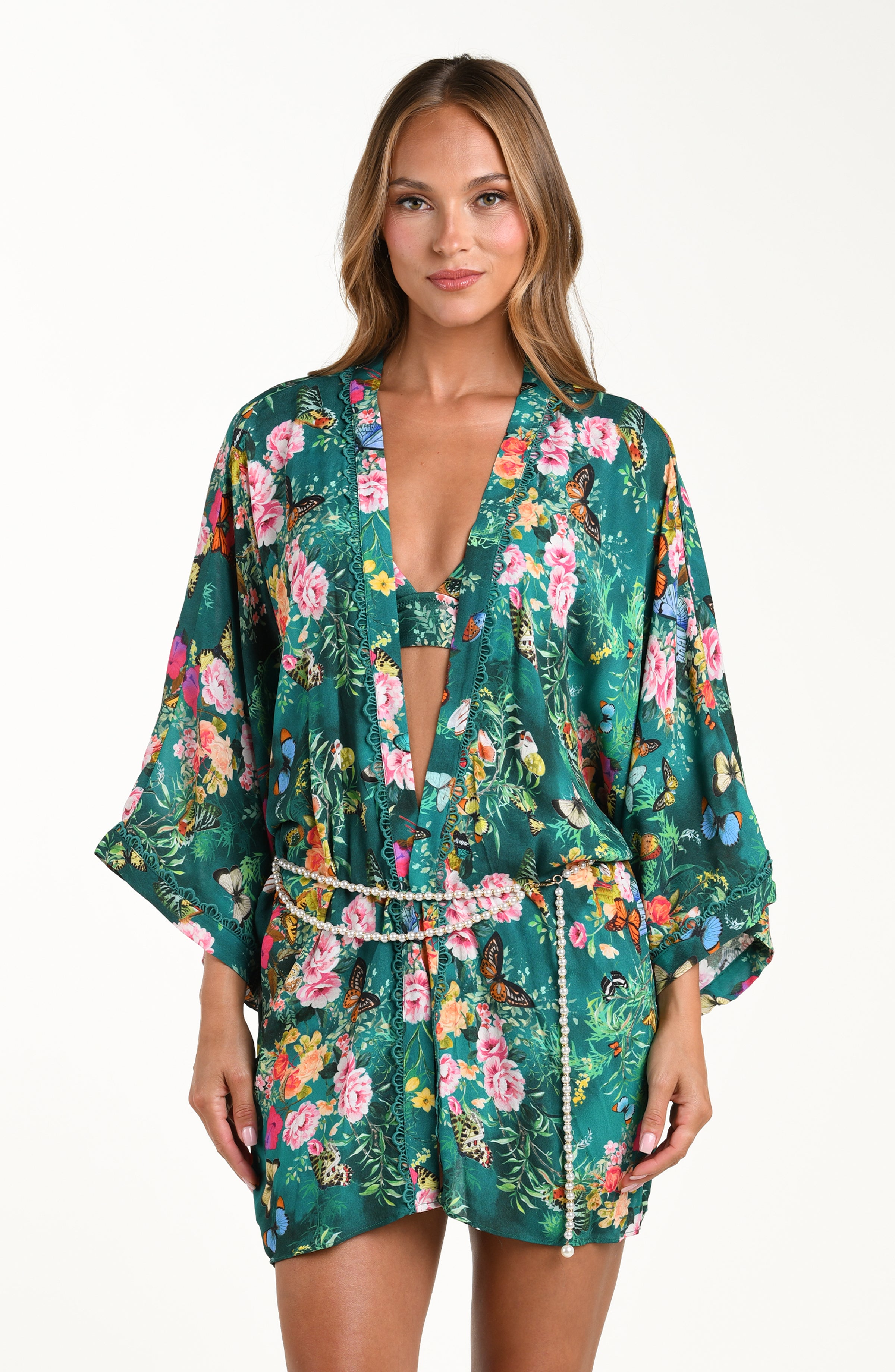 Front image of model wearing a multicolored floral printed kimono cover up featuring an open front, long wide sleeves, and a removable faux pearl belt. 