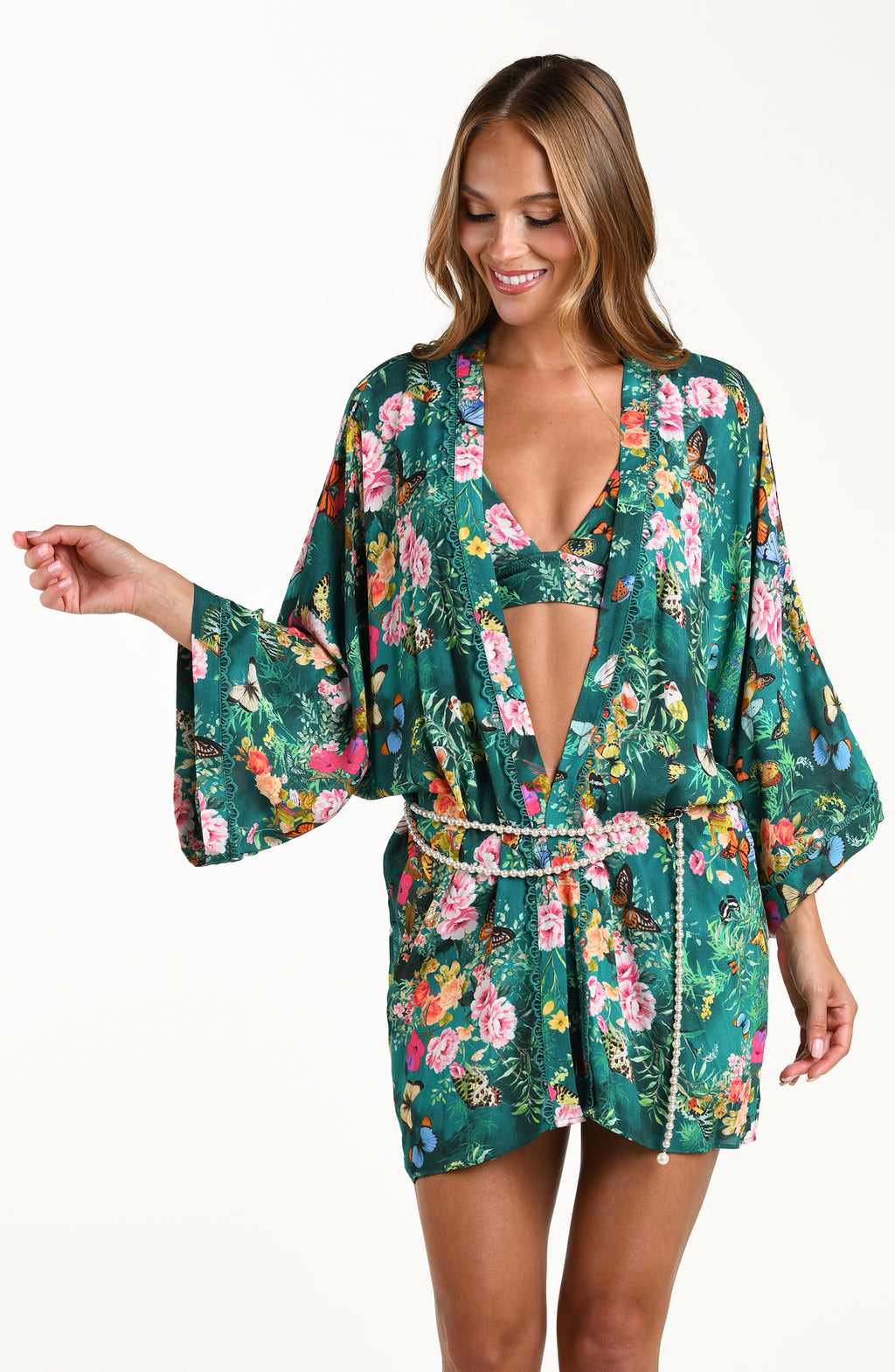 Front image of model wearing a multicolored floral printed kimono cover up featuring an open front, long wide sleeves, and a removable faux pearl belt. 