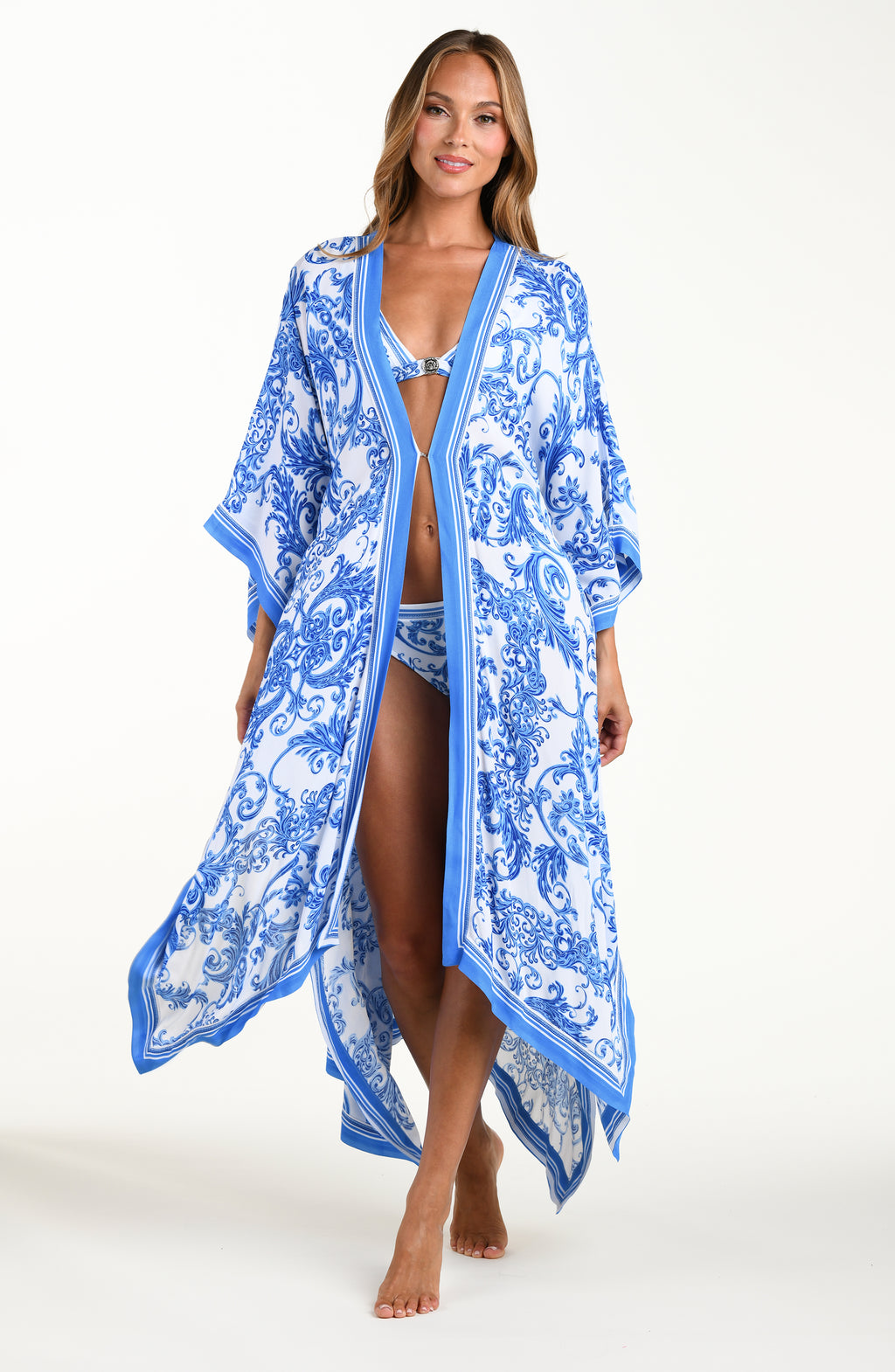 Woman wearing a blue and white patterned kimono over a swimsuit on a white background