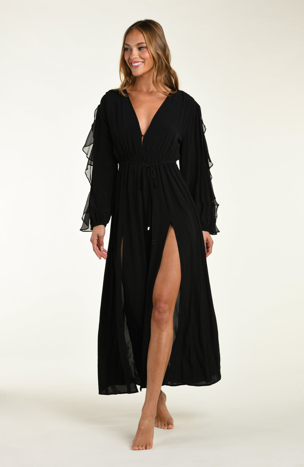 Woman wearing a black dress with sheer sleeves on a white background