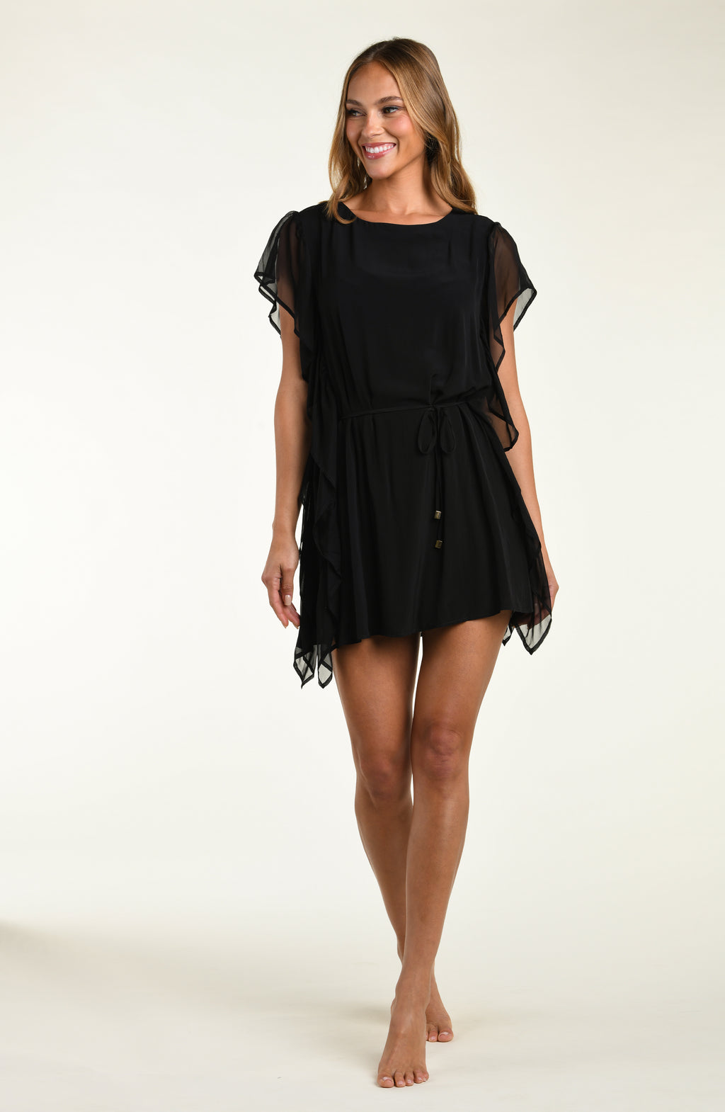 Woman wearing a black dress with sheer sleeves on a white background