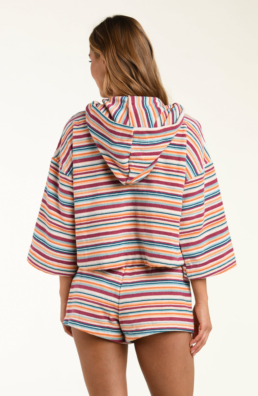 Person wearing a colorful striped hoodie and shorts set on a white background
