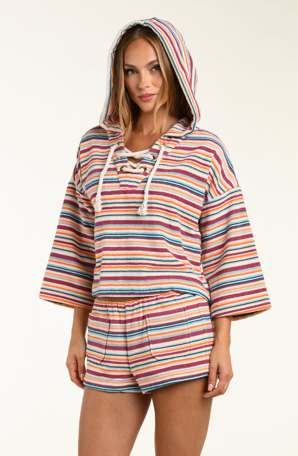 Woman wearing a colorful striped hoodie and shorts set on a white background