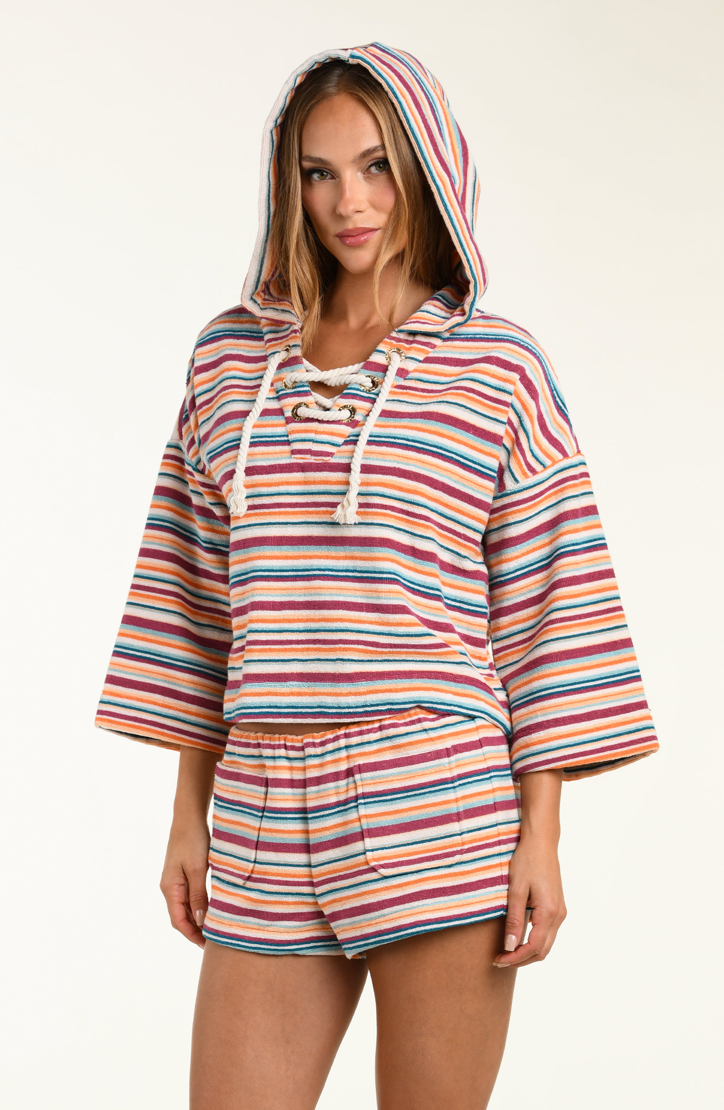 Woman wearing a colorful striped hoodie and shorts set on a white background