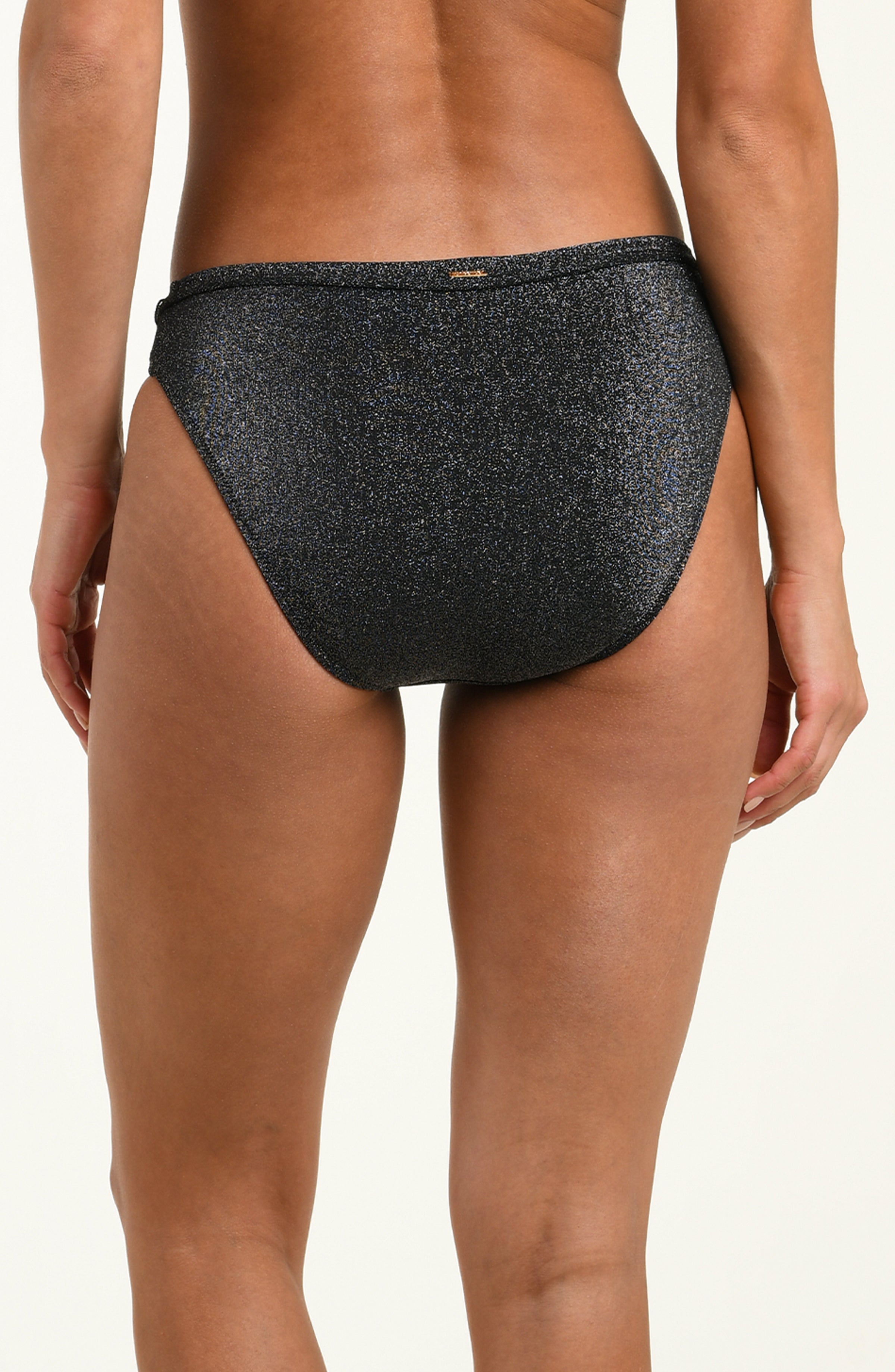 Black sparkly bikini bottom worn by a person on a beige background
