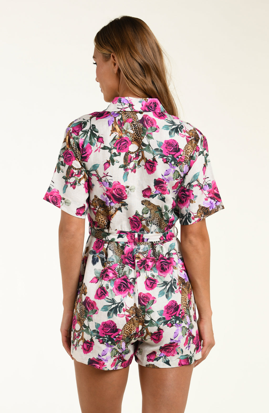Woman wearing a floral romper with a white background