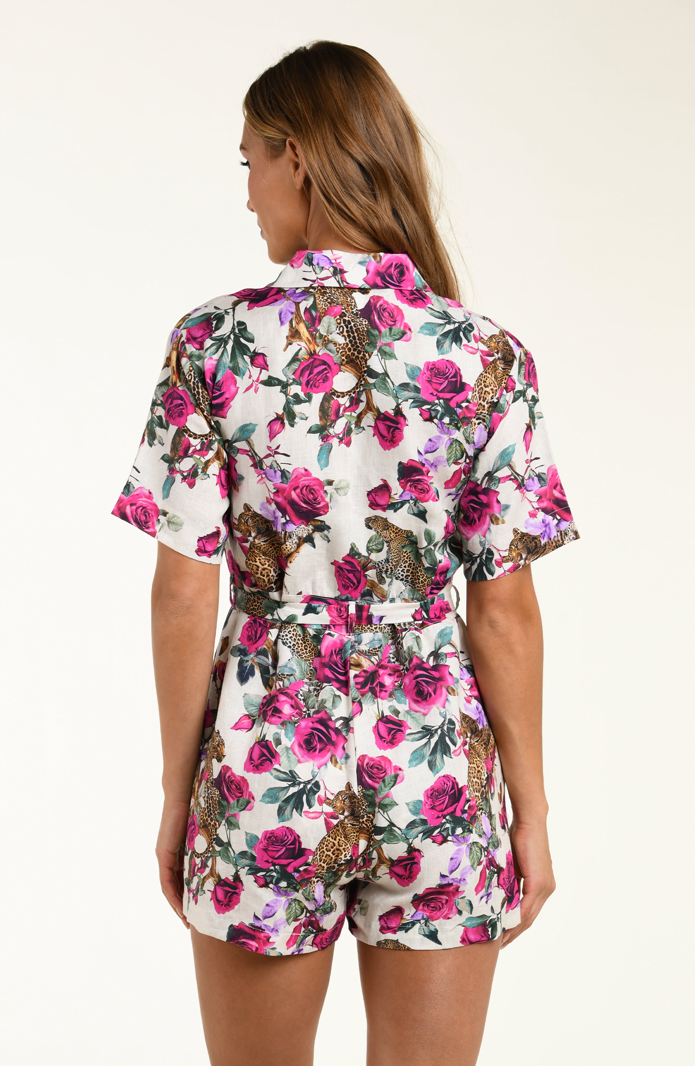 Woman wearing a floral romper with a white background