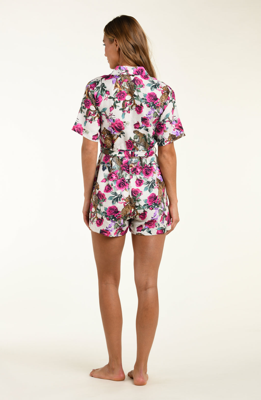 Woman wearing a floral romper on a white background