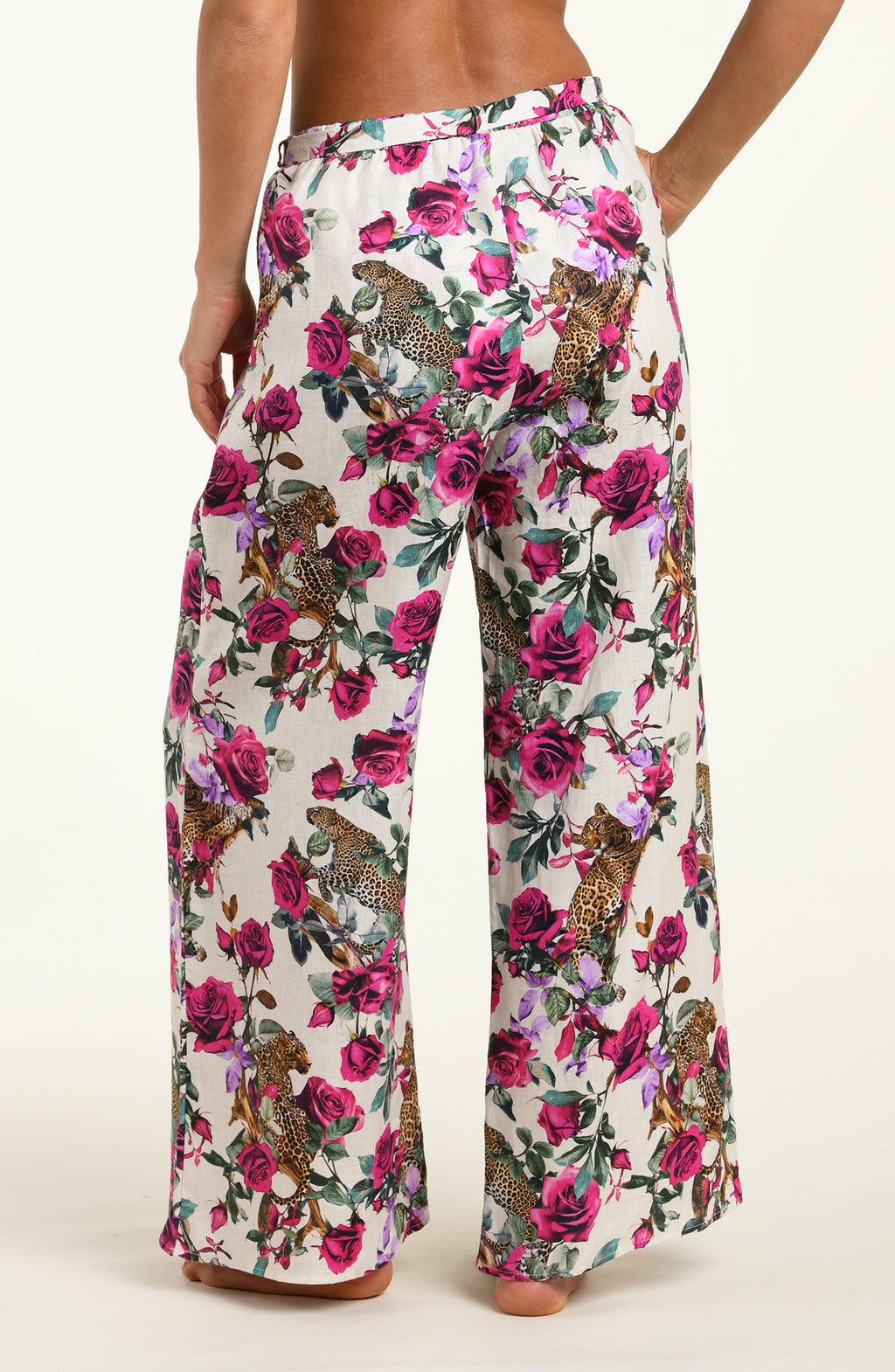Floral patterned pants with pink flowers and animal designs on a white background