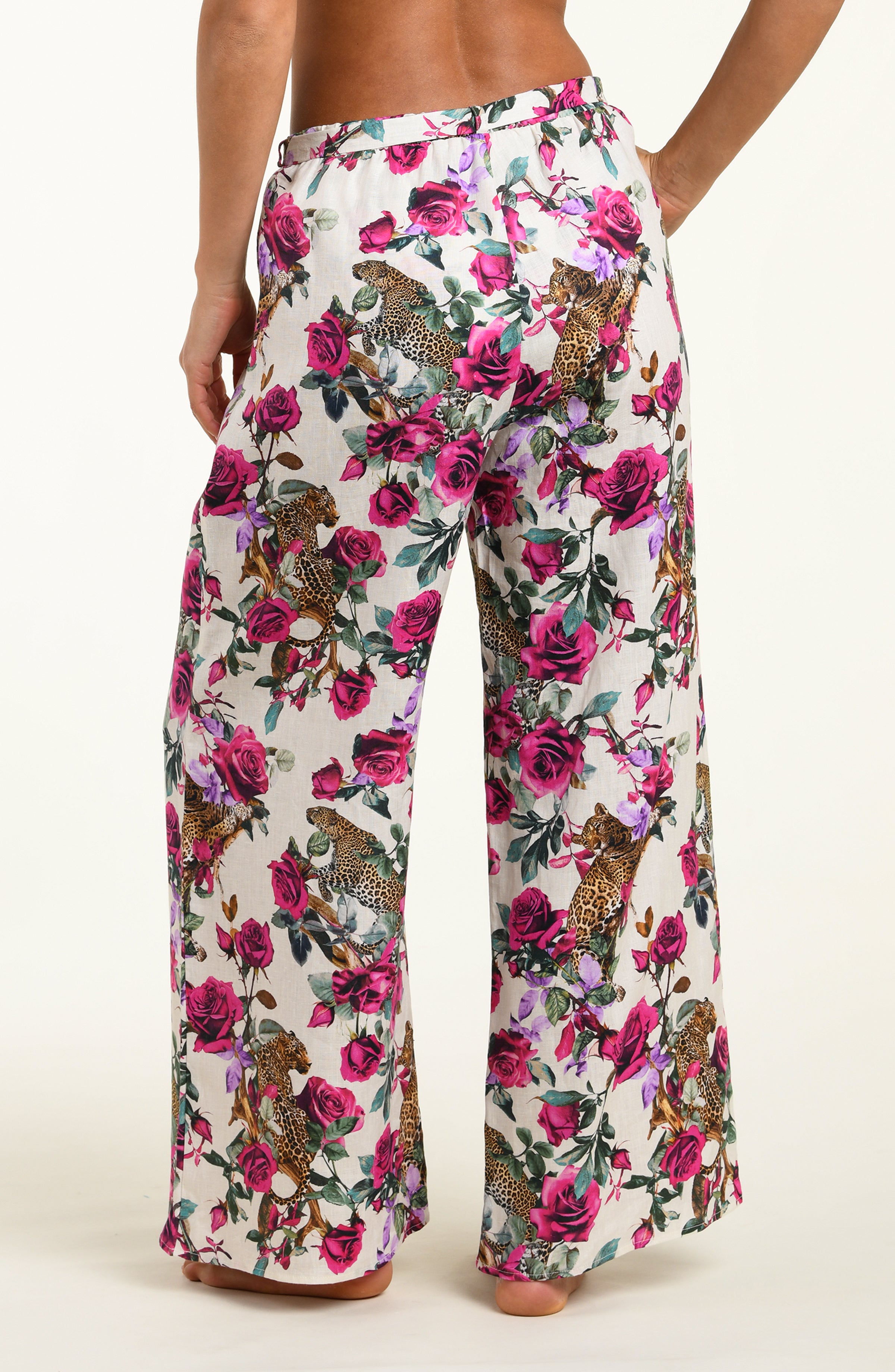 Floral patterned pants with pink flowers and animal designs on a white background