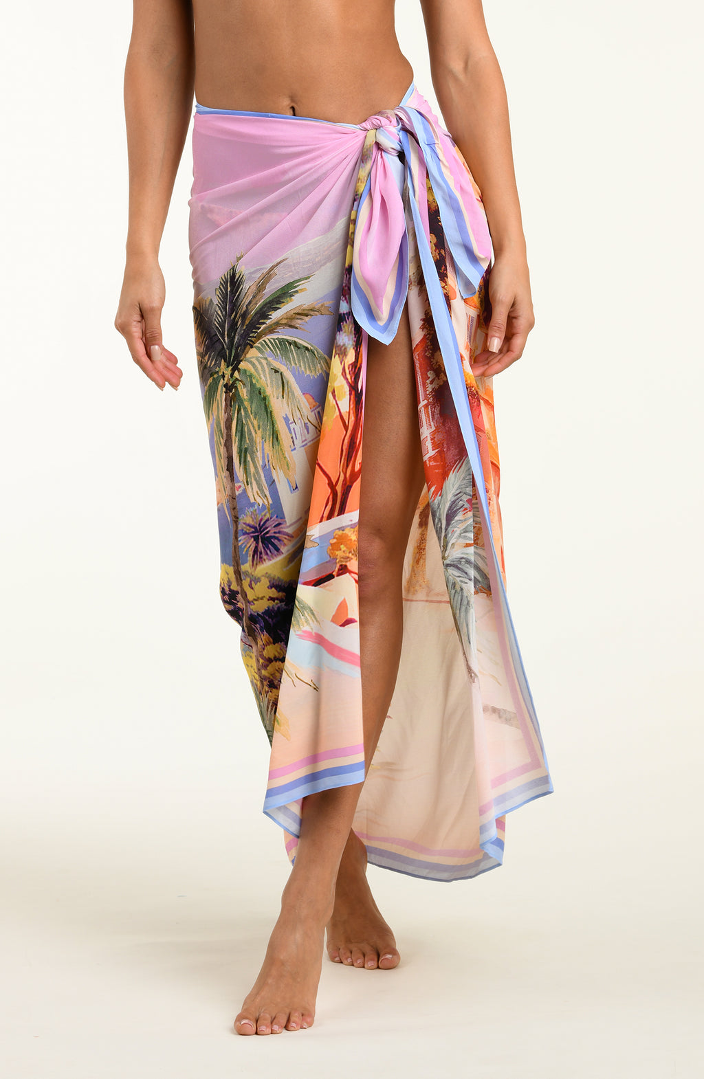 Person wearing a colorful tropical print sarong on a white background
