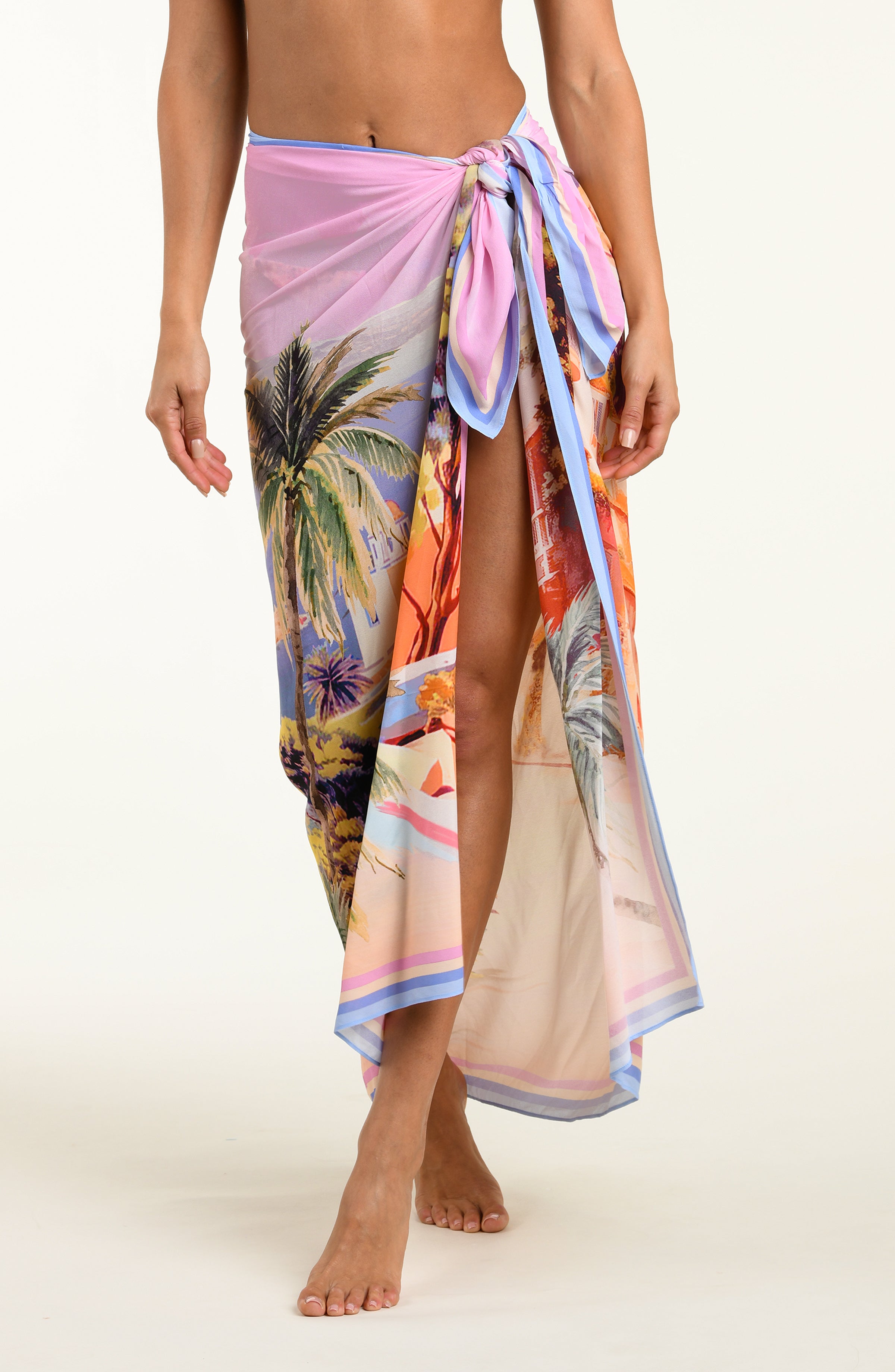 Person wearing a colorful tropical print sarong on a white background