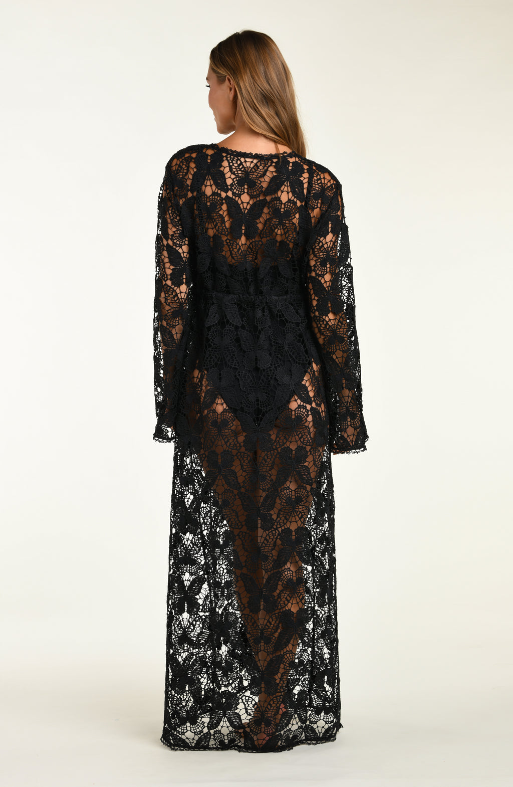 Woman wearing a black lace dress on a white background