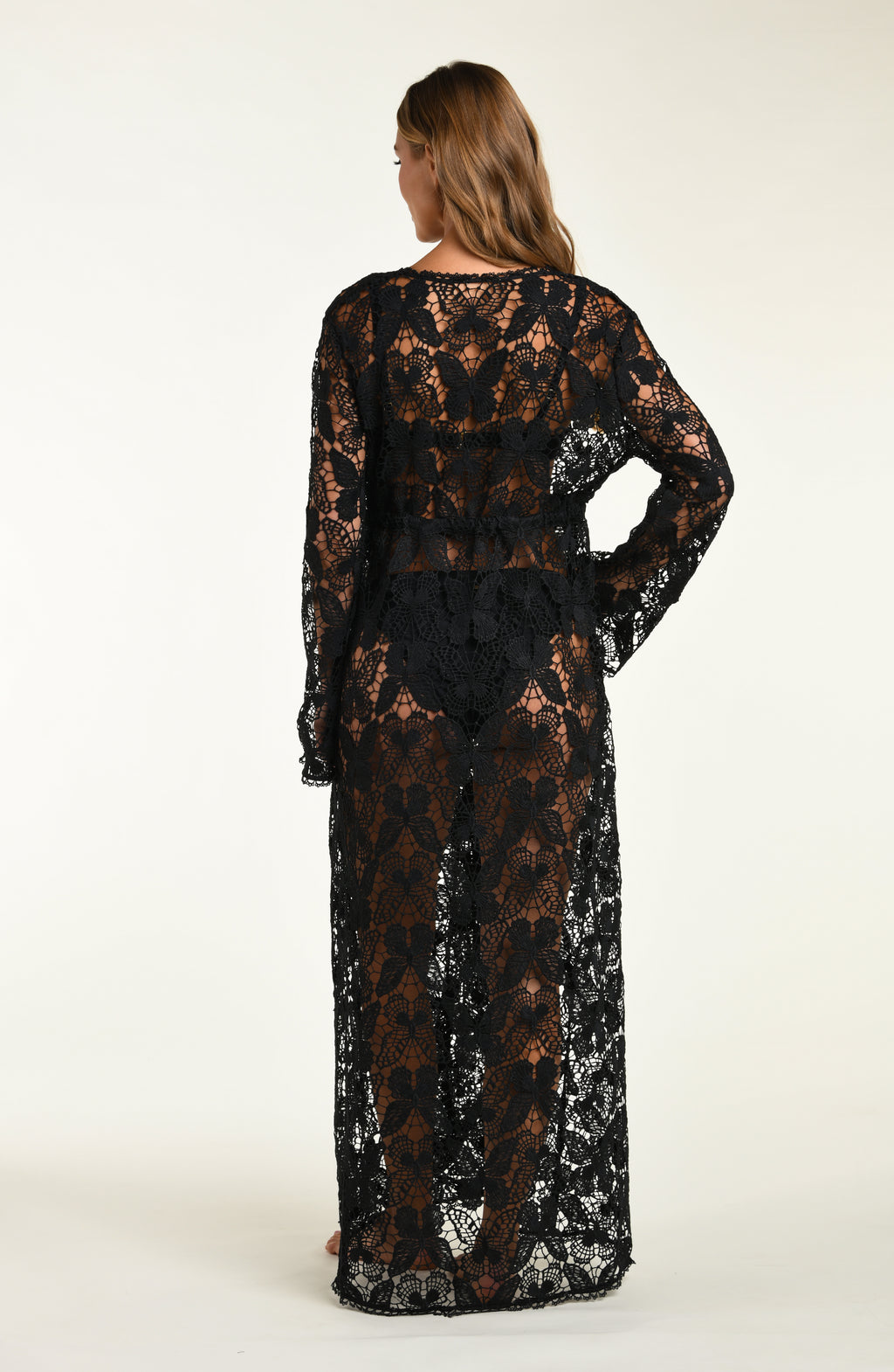 Woman wearing a black lace dress against a white background