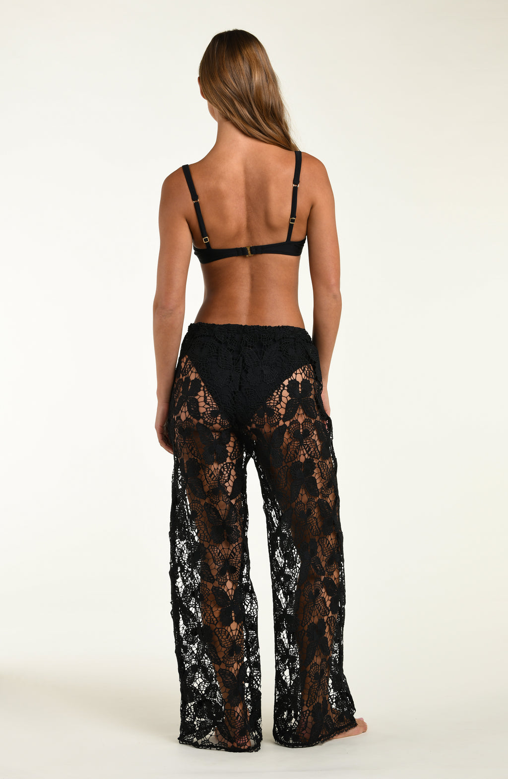 Person wearing black lace lingerie on a white background