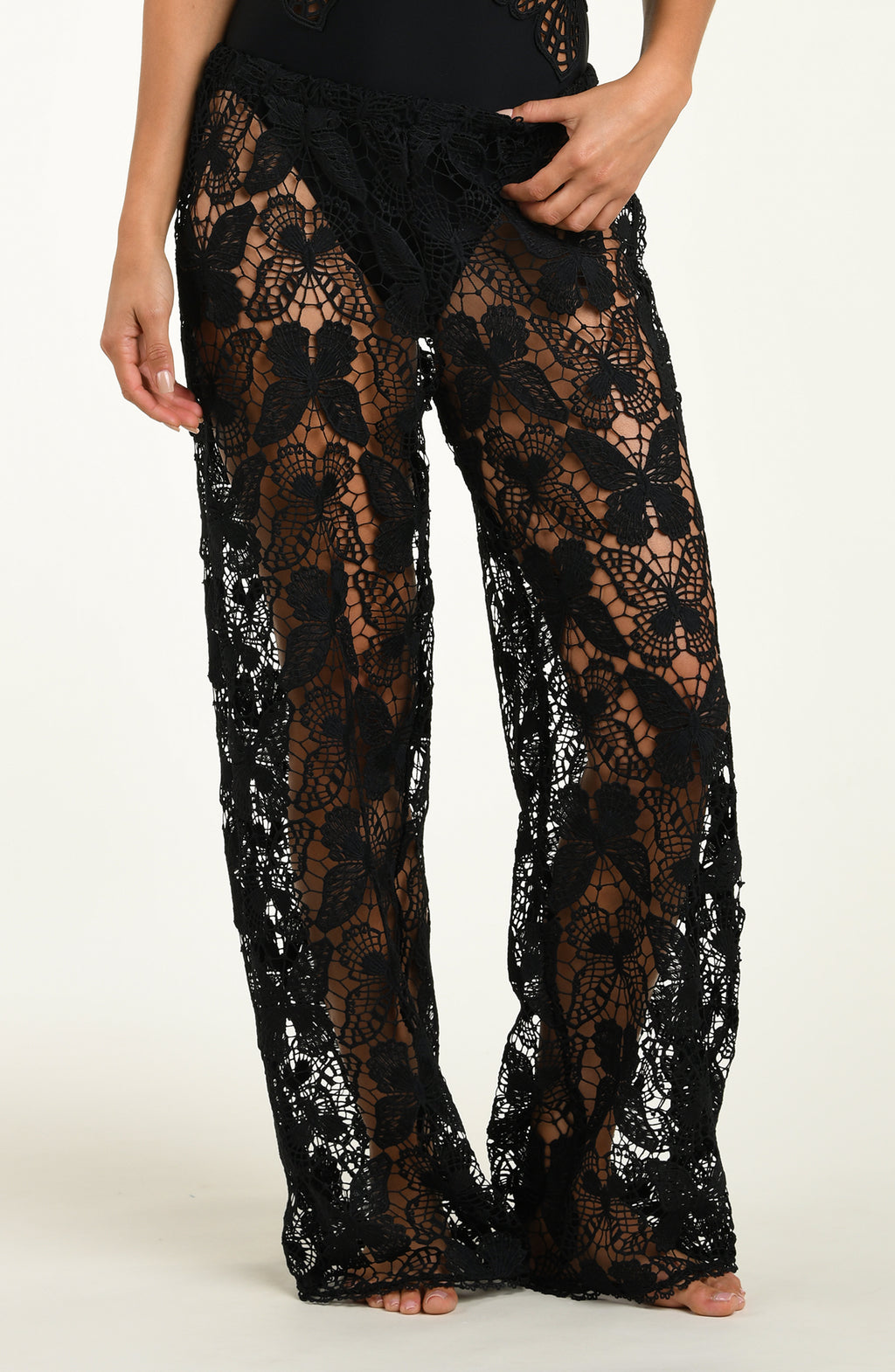Black lace pants with sequin detailing on a white background