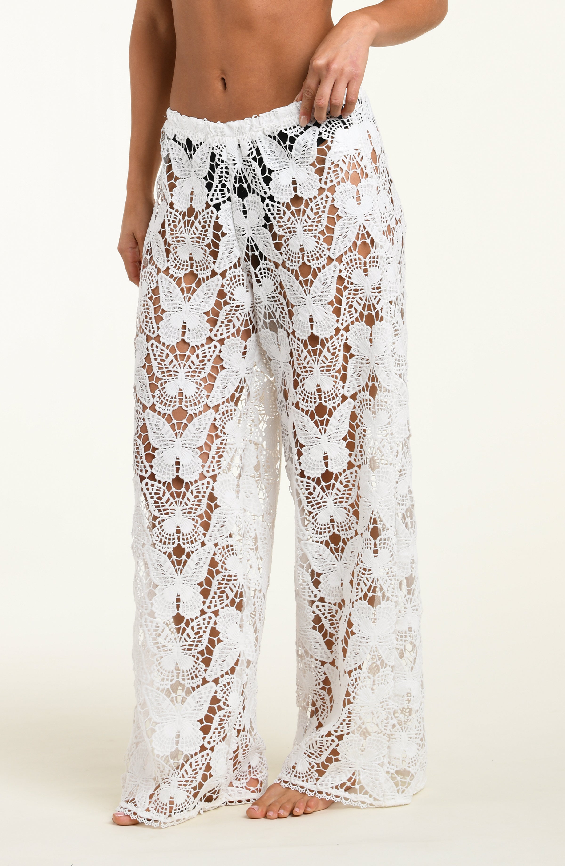 White lace pants worn by a person on a white background