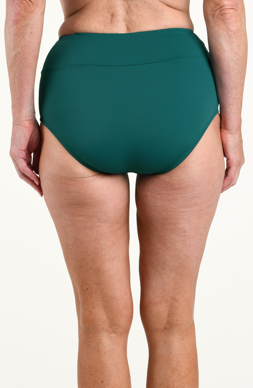 Woman wearing a solid jungle green mid waist bottom against a white background. 