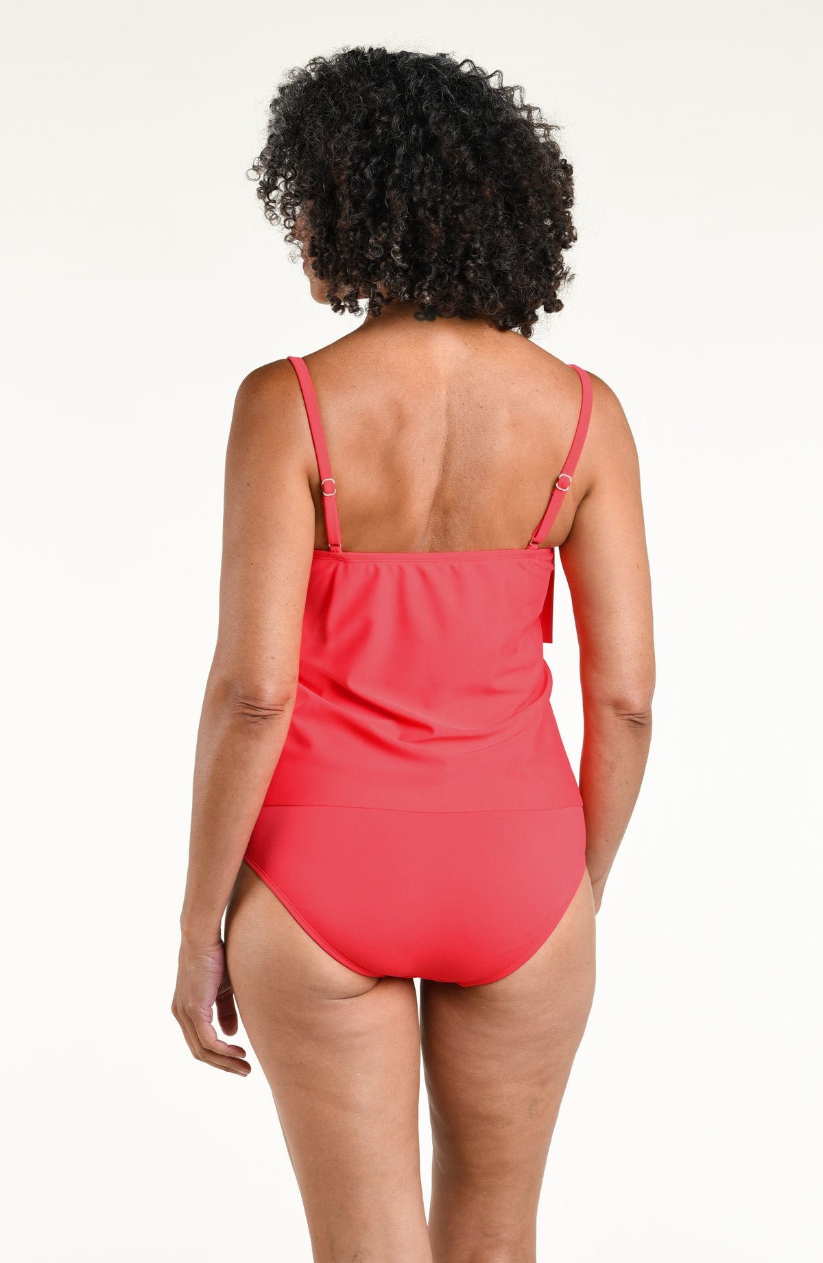 Woman wearing a solid orange colored tiered tankini top and matching bottom against a white background. 