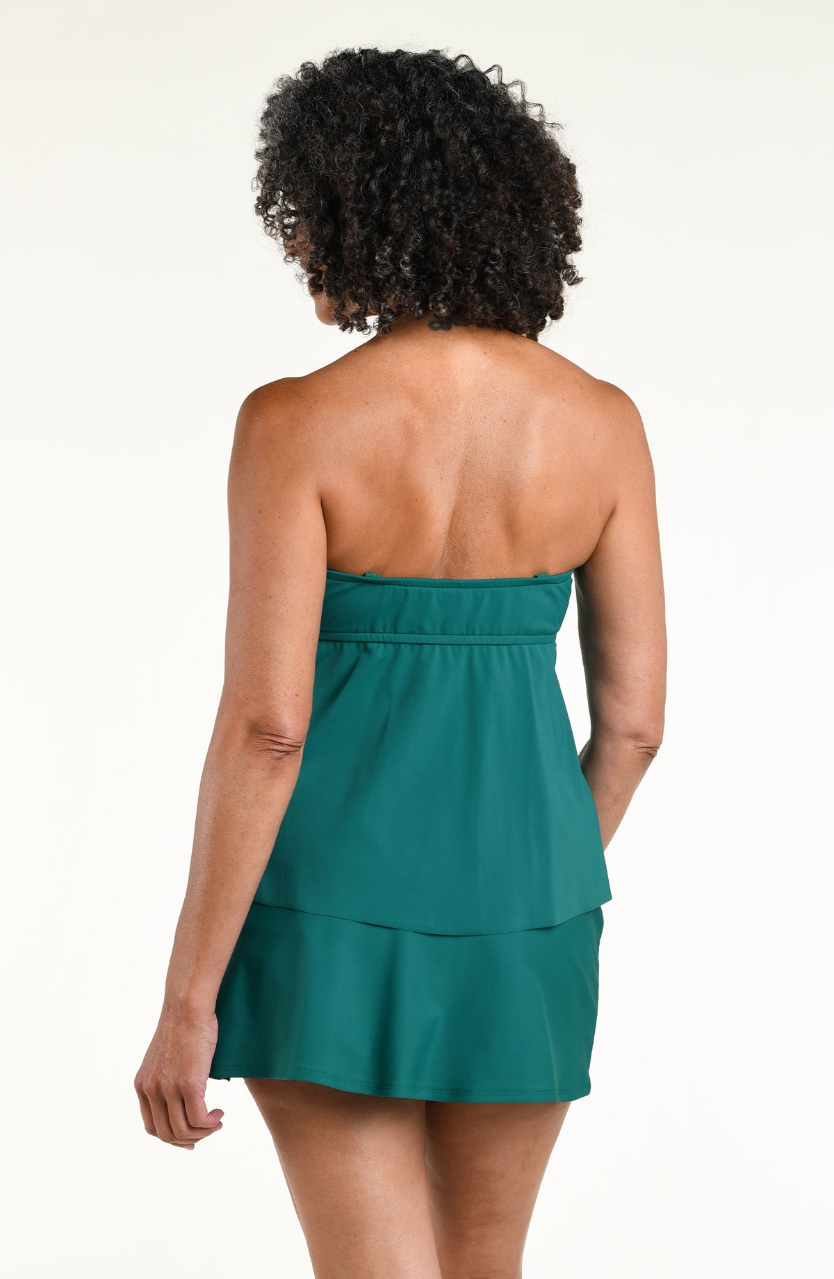 Woman wearing a jungle green tankini top and matching swim skirt against a white background 