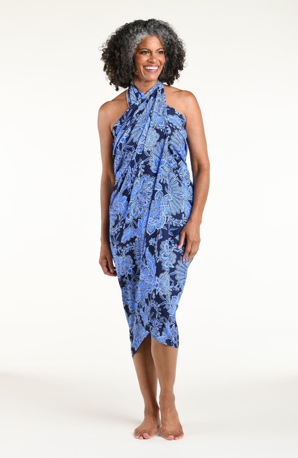 Woman wearing an indigo blue multicolored sarong against a white background. 