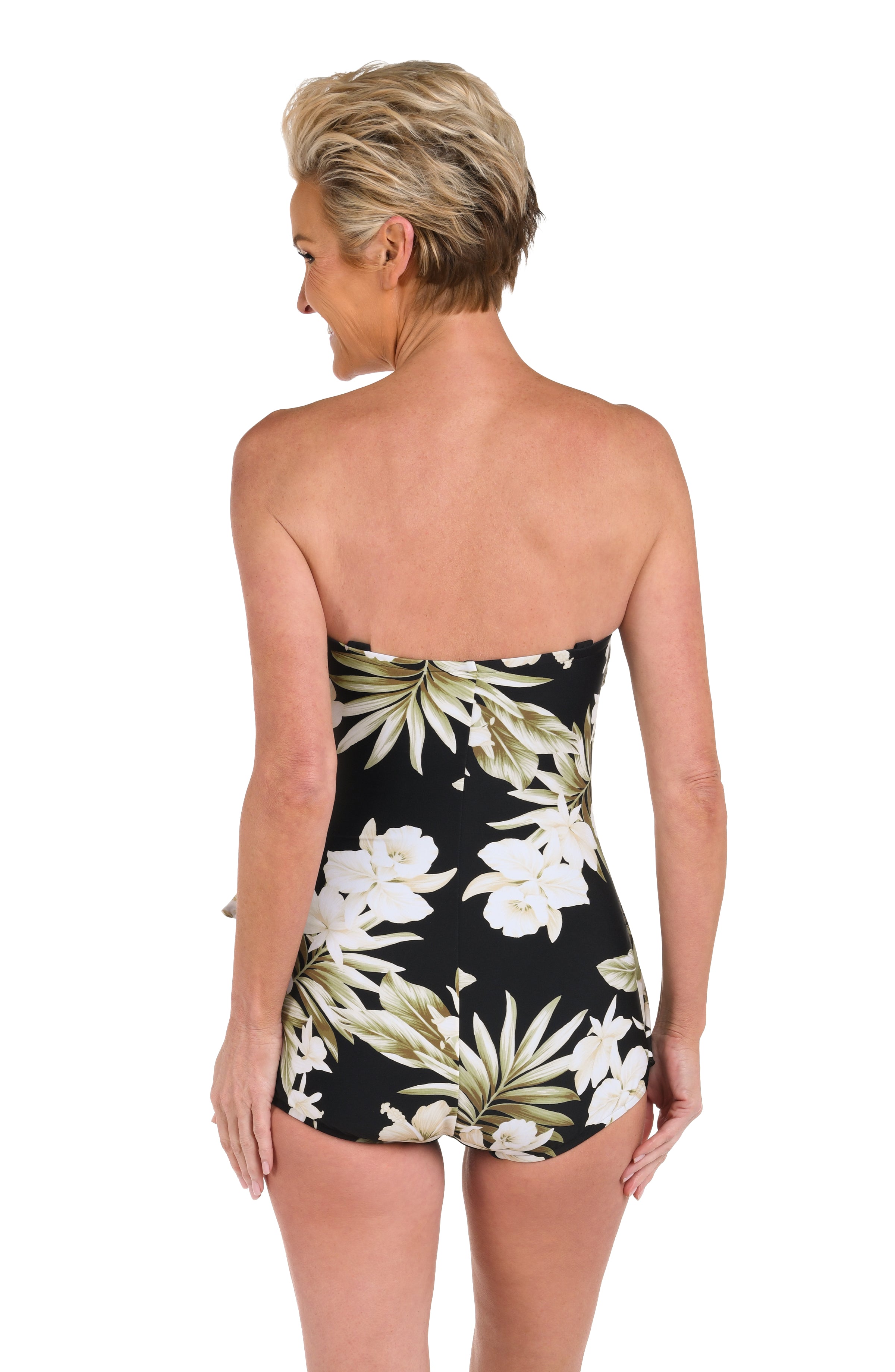 Woman wearing a black floral printed bandeau one piece swimsuit against a white background.