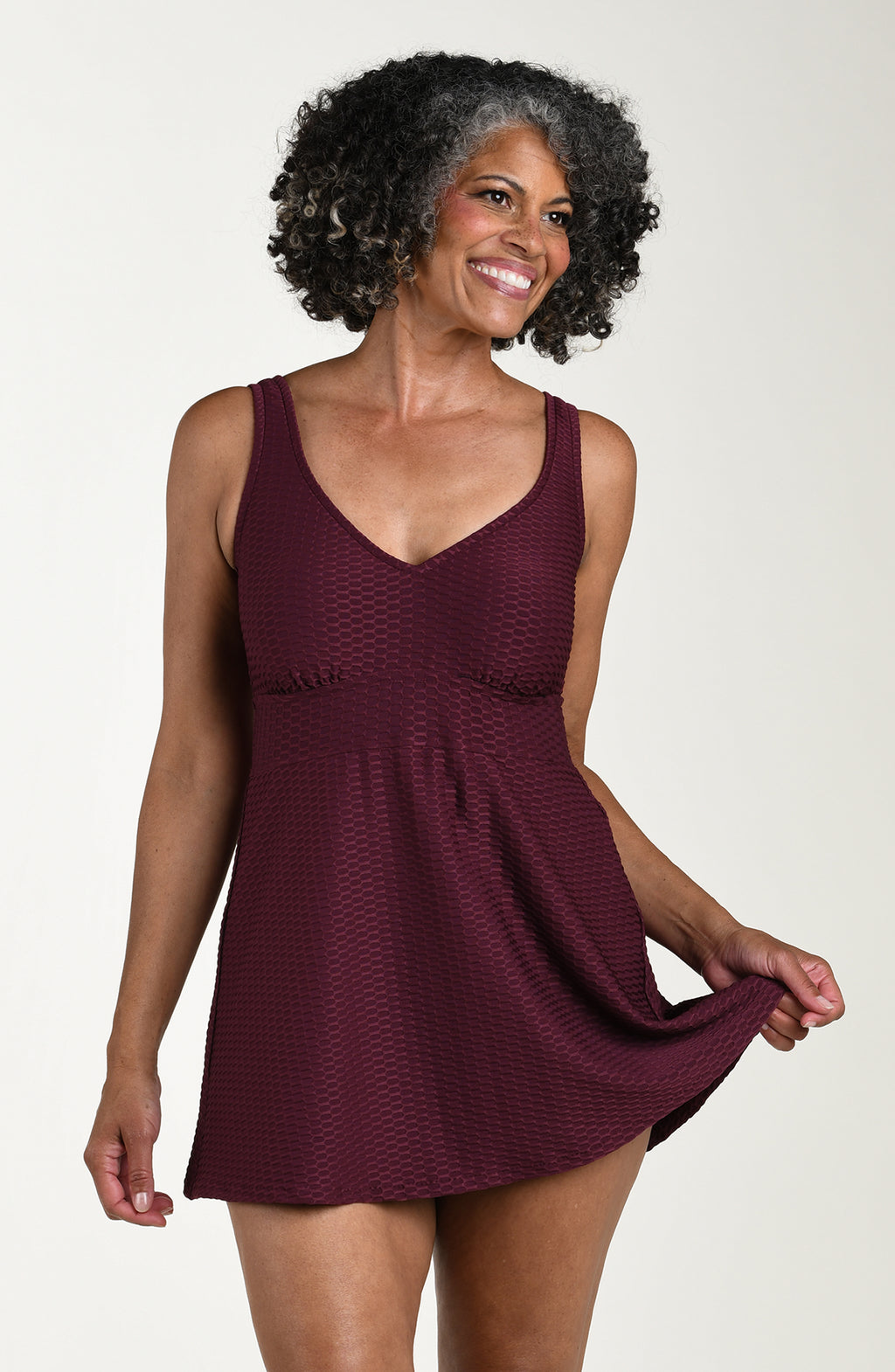 Woman wearing a burgundy dress against a plain background