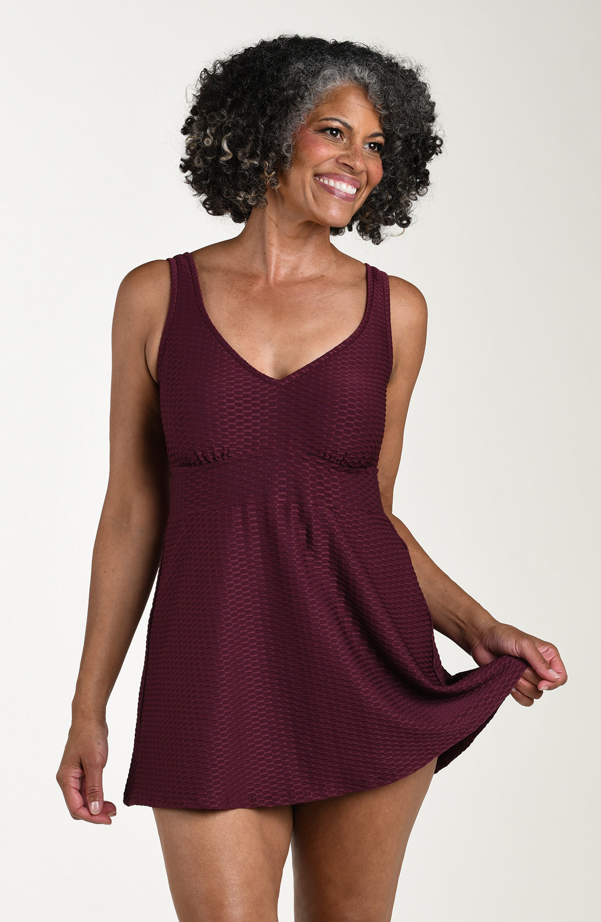 Woman wearing a burgundy dress against a plain background