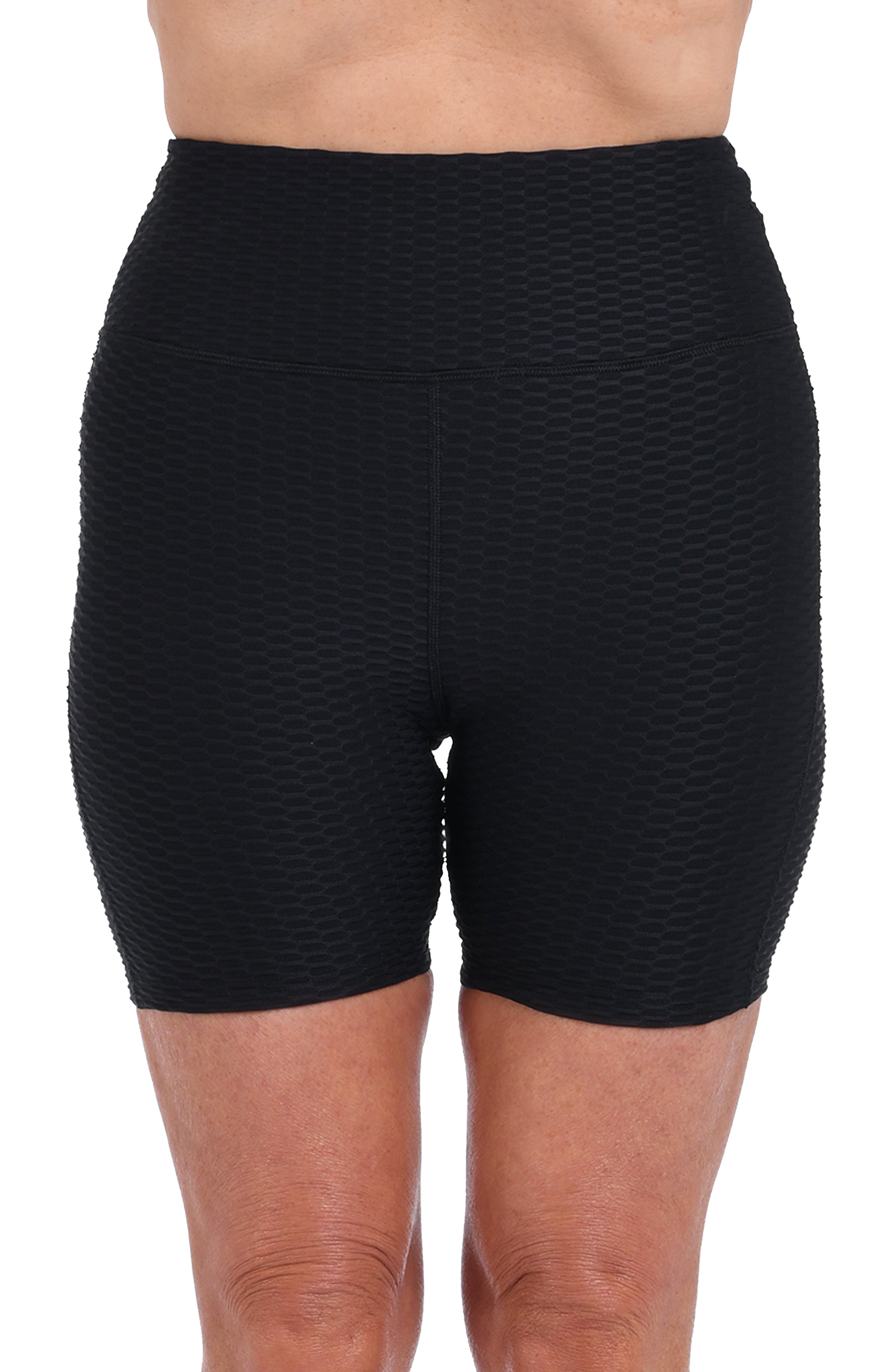 Black textured biker shorts worn by a person on a white background