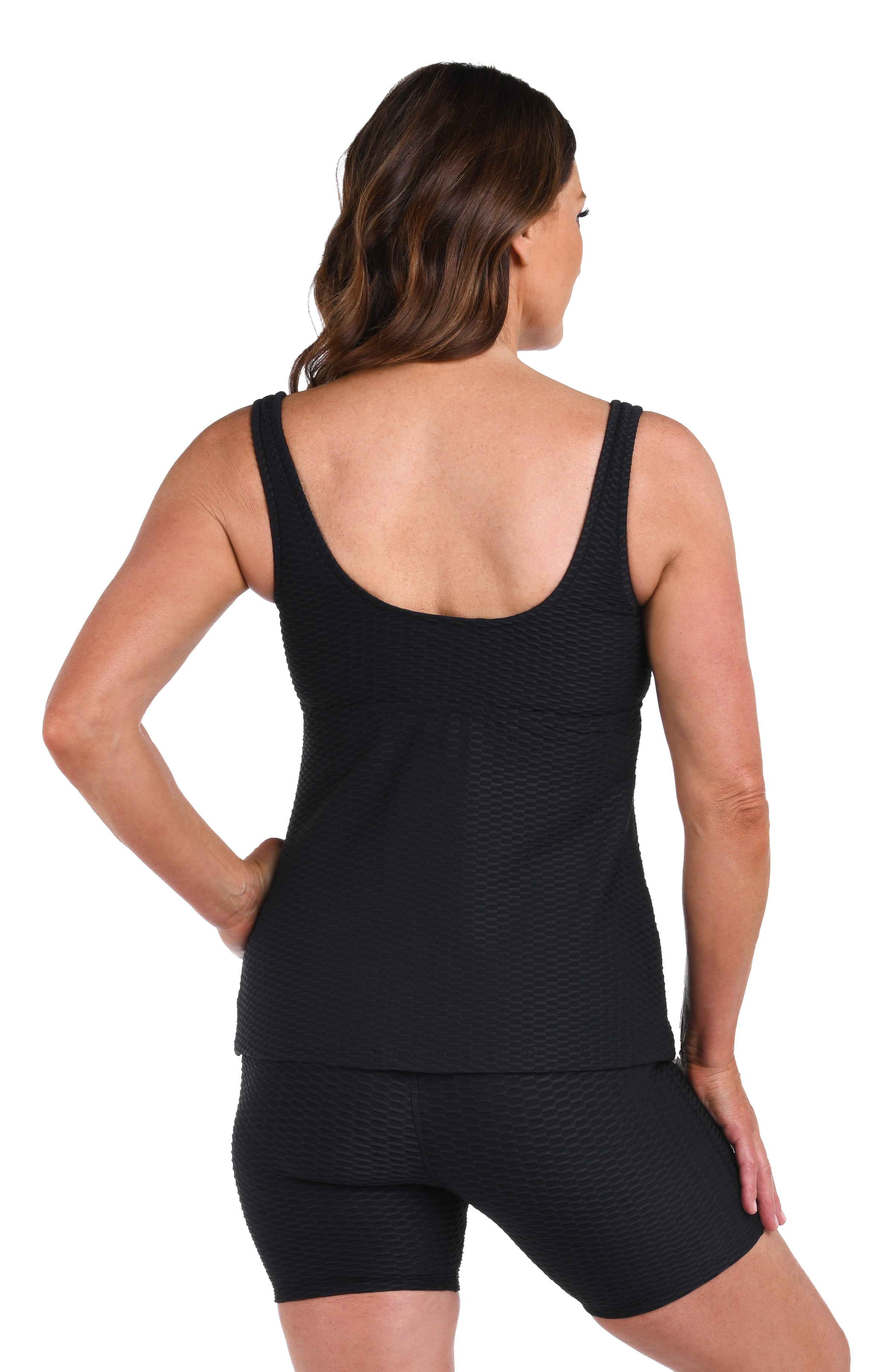 Woman wearing a black tankini top and shorts set on a white background