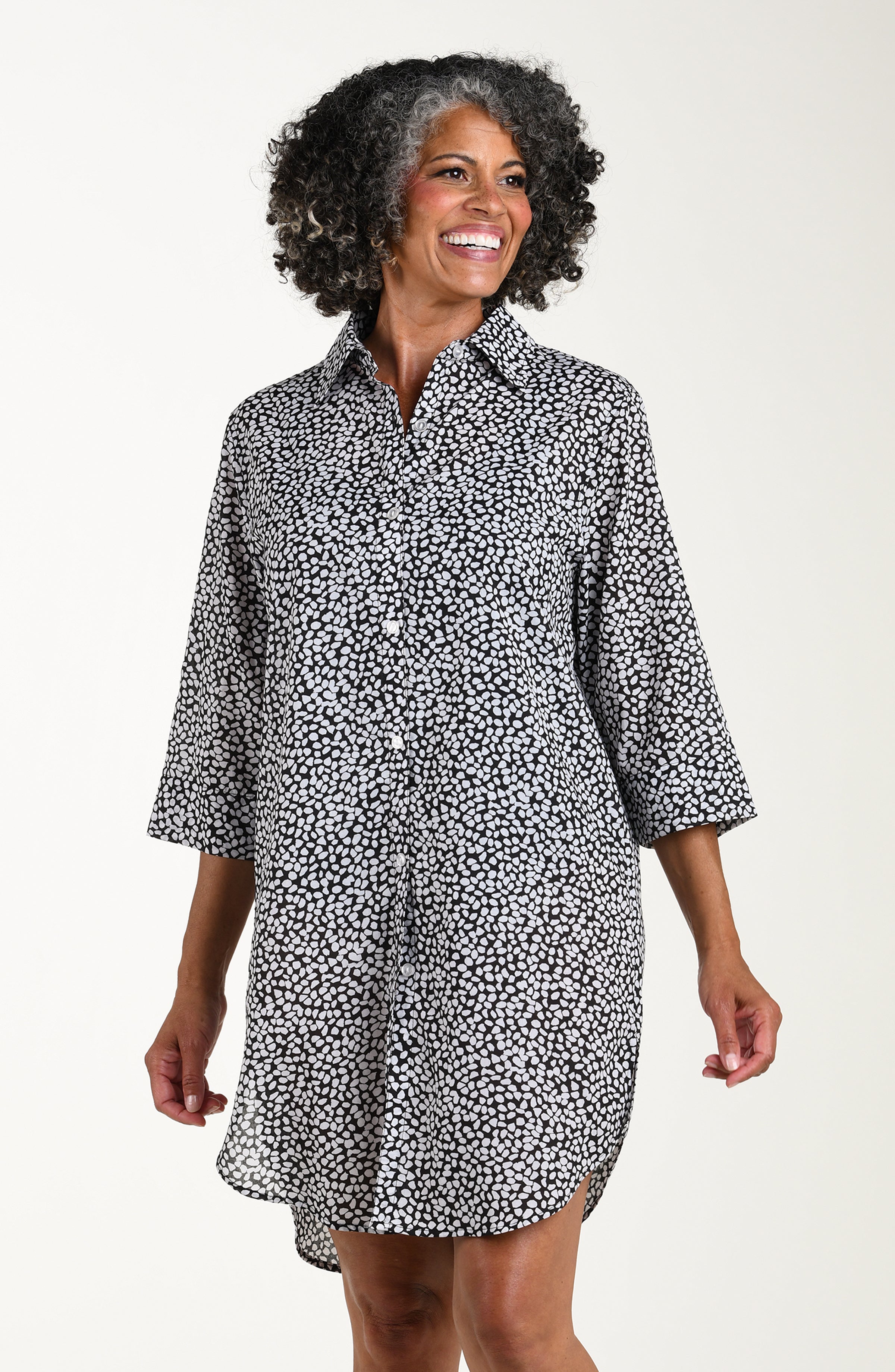 Woman wearing a black and white patterned dress on a white background