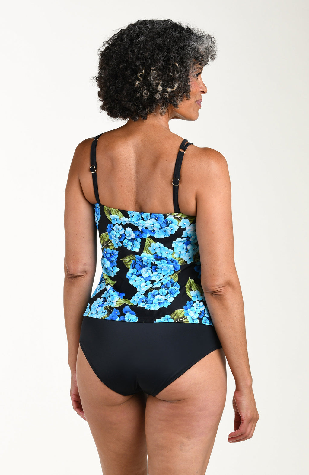 Woman wearing a black swimsuit with blue floral pattern on a white background
