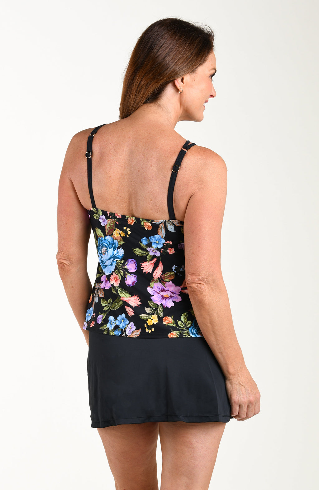 Woman wearing a black tank top with colorful floral pattern on a white background