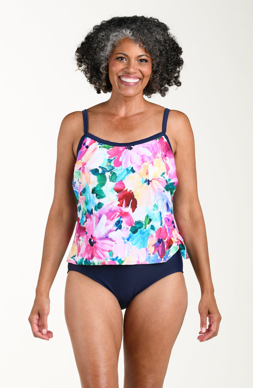 Woman wearing a floral tankini set on a plain background