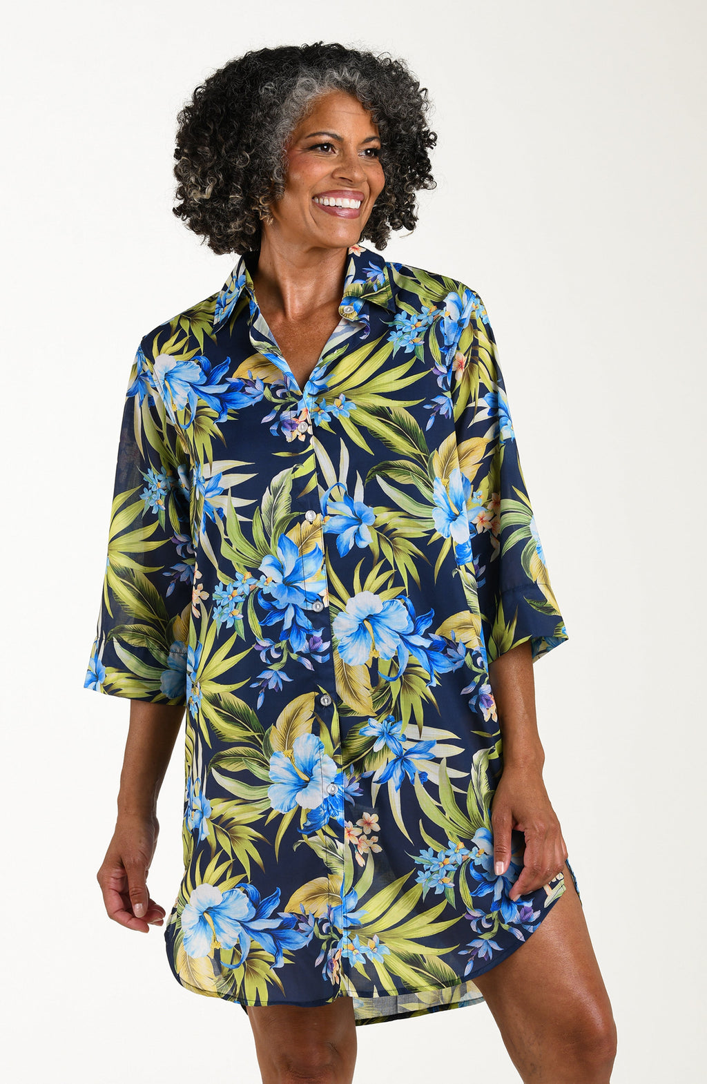 Front image of model wearing a multicolored (blue) tropical tunic cover up featuring a collared button front and three quarter sleeves. 