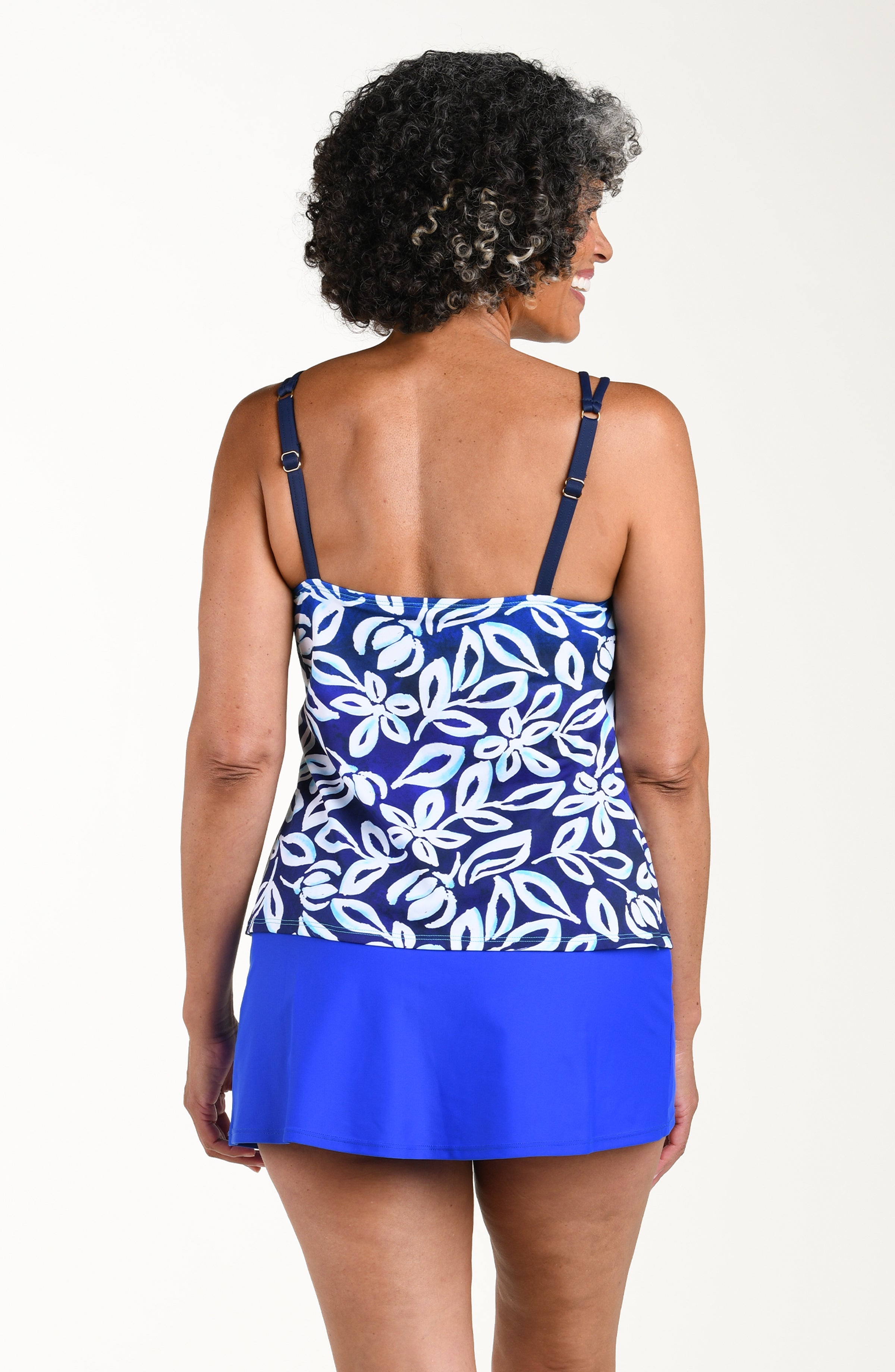 Woman wearing a blue and white floral dress against a white background