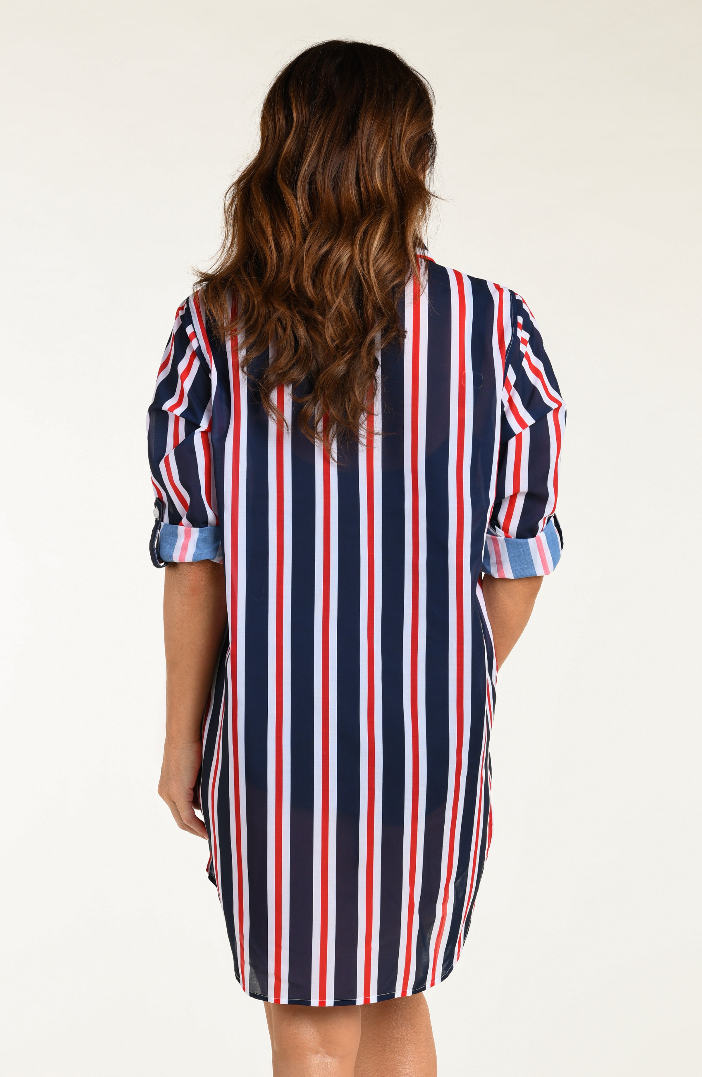 Woman wearing a red, white, and blue striped button down tunic against a white background.