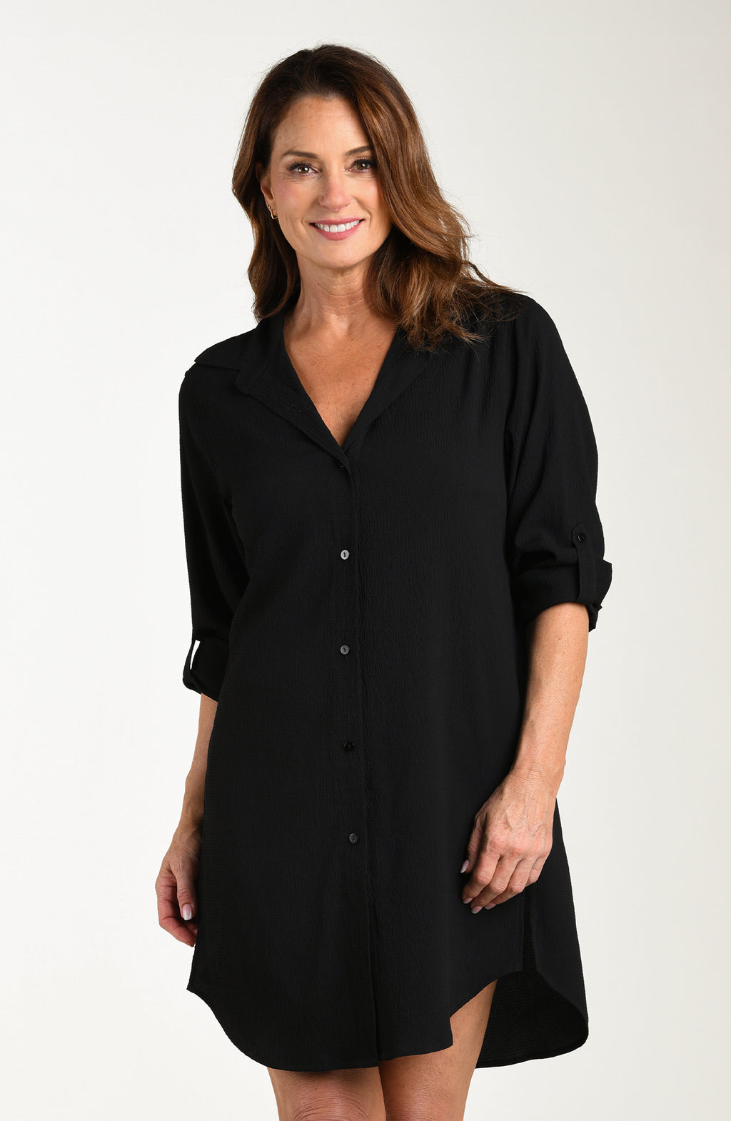 Woman wearing a black shirt dress against a white background