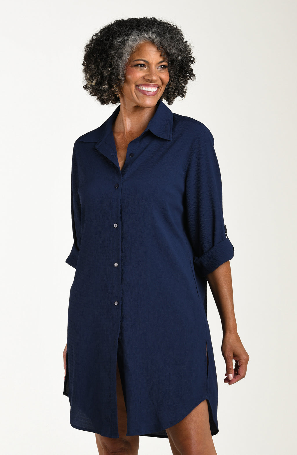 Woman wearing a navy blue shirt dress against a white background