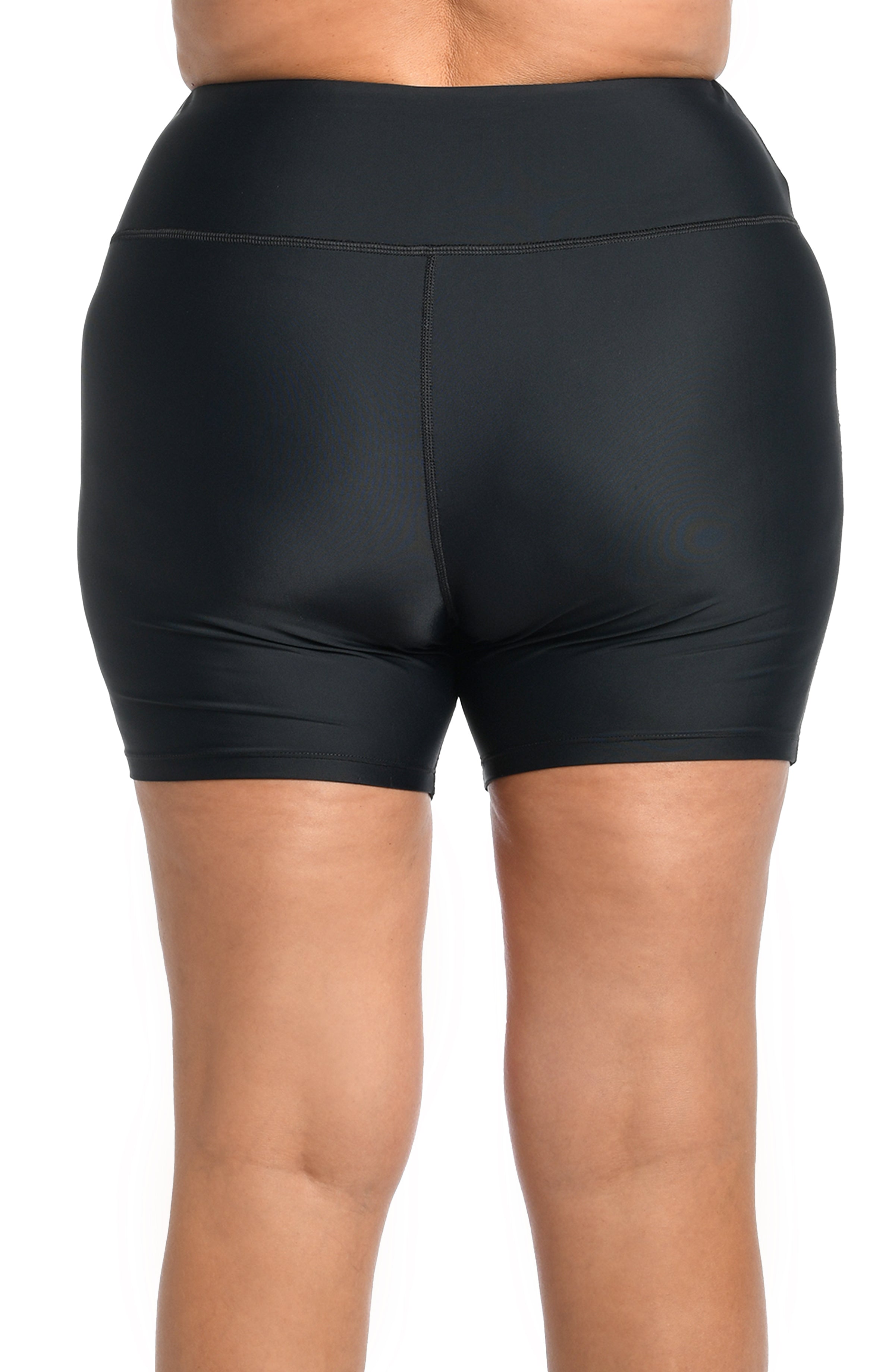 Black bike shorts worn by a person on a white background