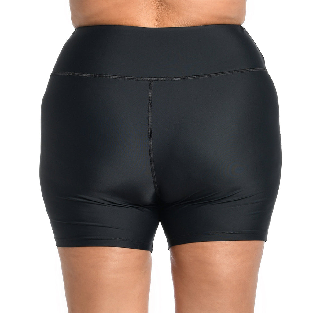 Black bike shorts worn by a person on a white background