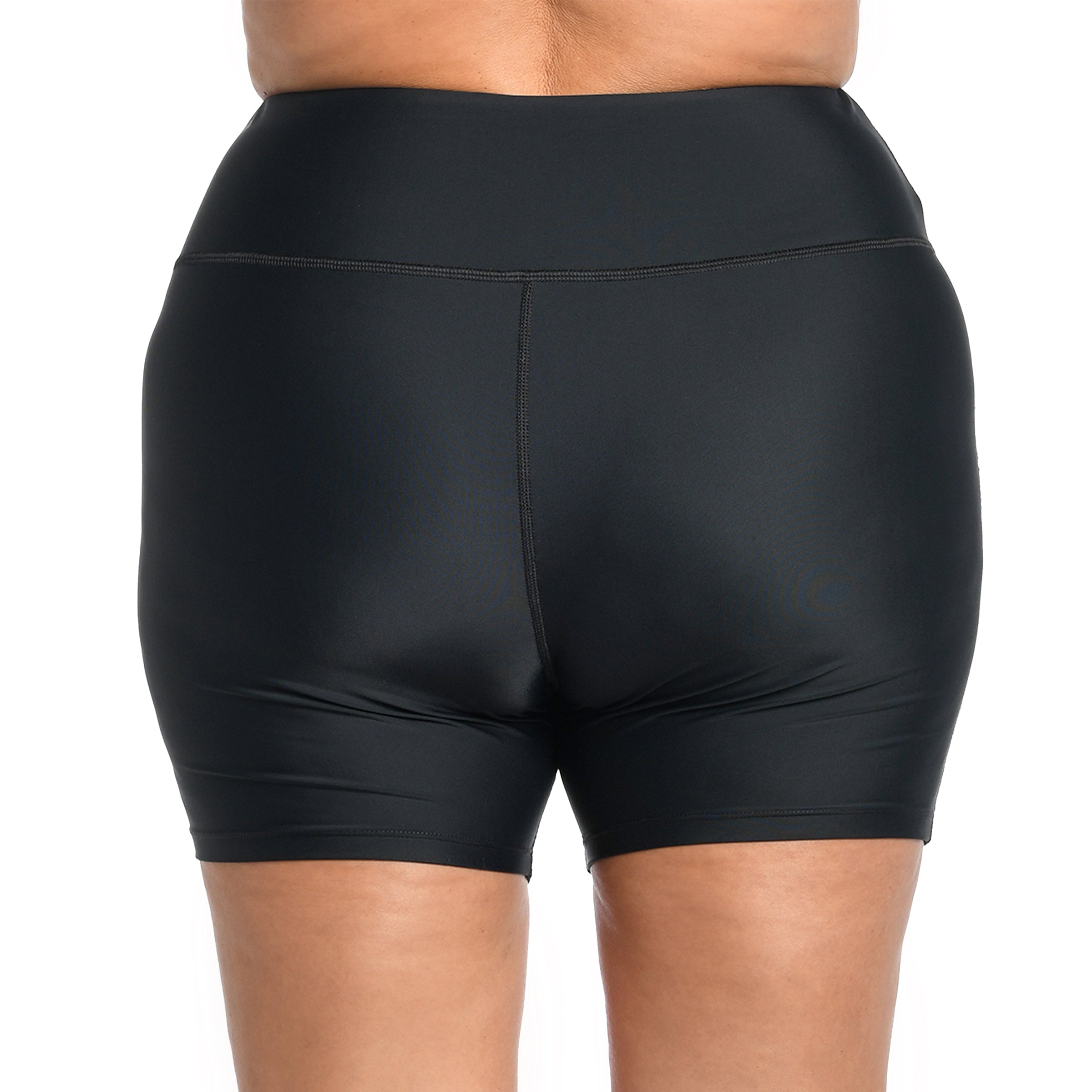 Black bike shorts worn by a person on a white background