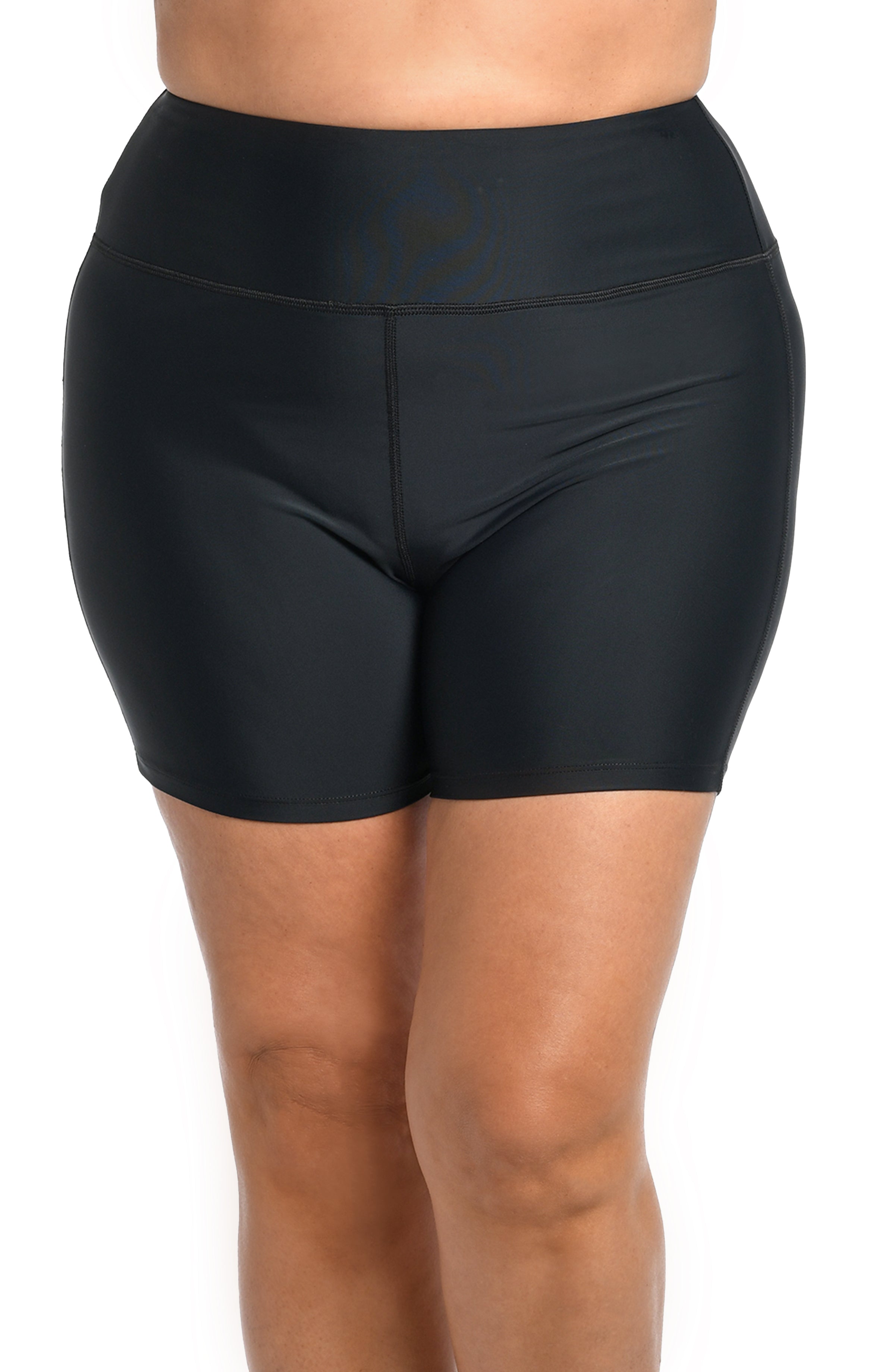 Black bike shorts worn by a person on a white background